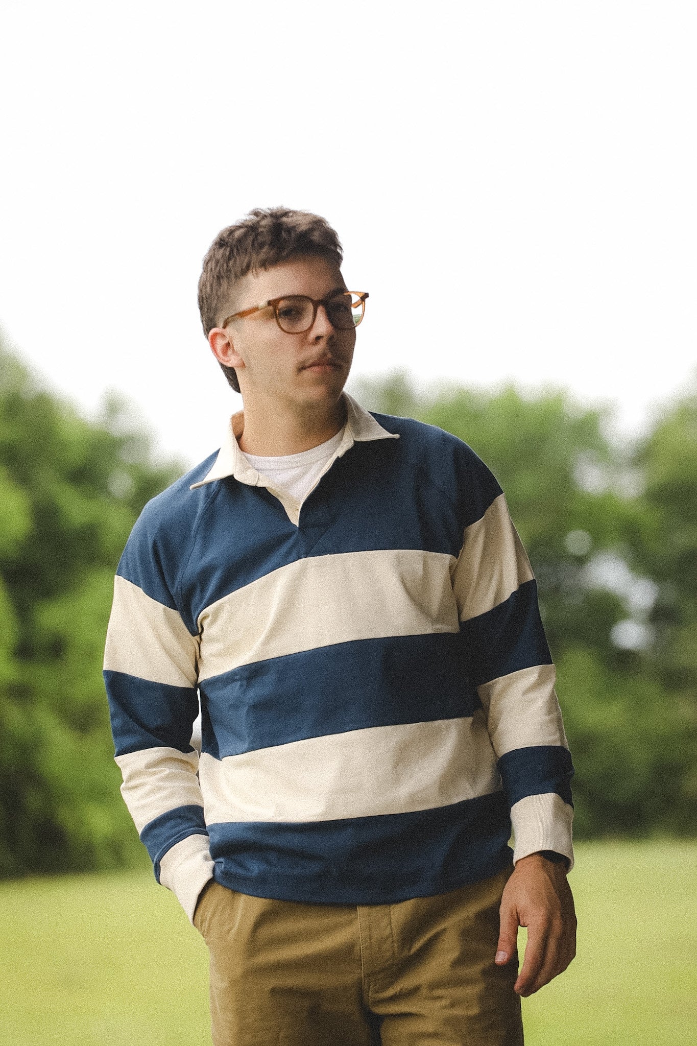 Man wearing a blue and white striped shirt with glasses outdoors