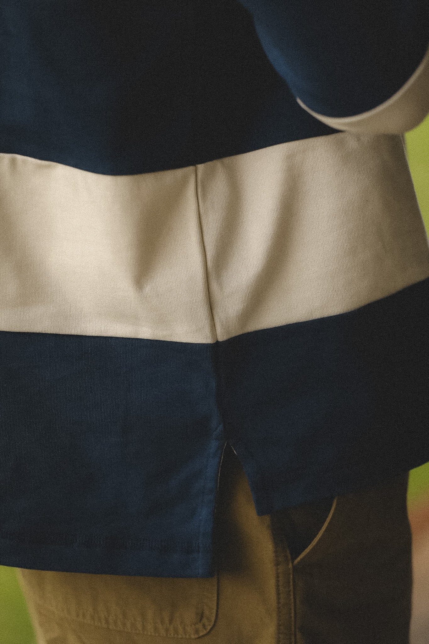 Close-up of a person wearing a navy and beige striped shirt with a blurred background