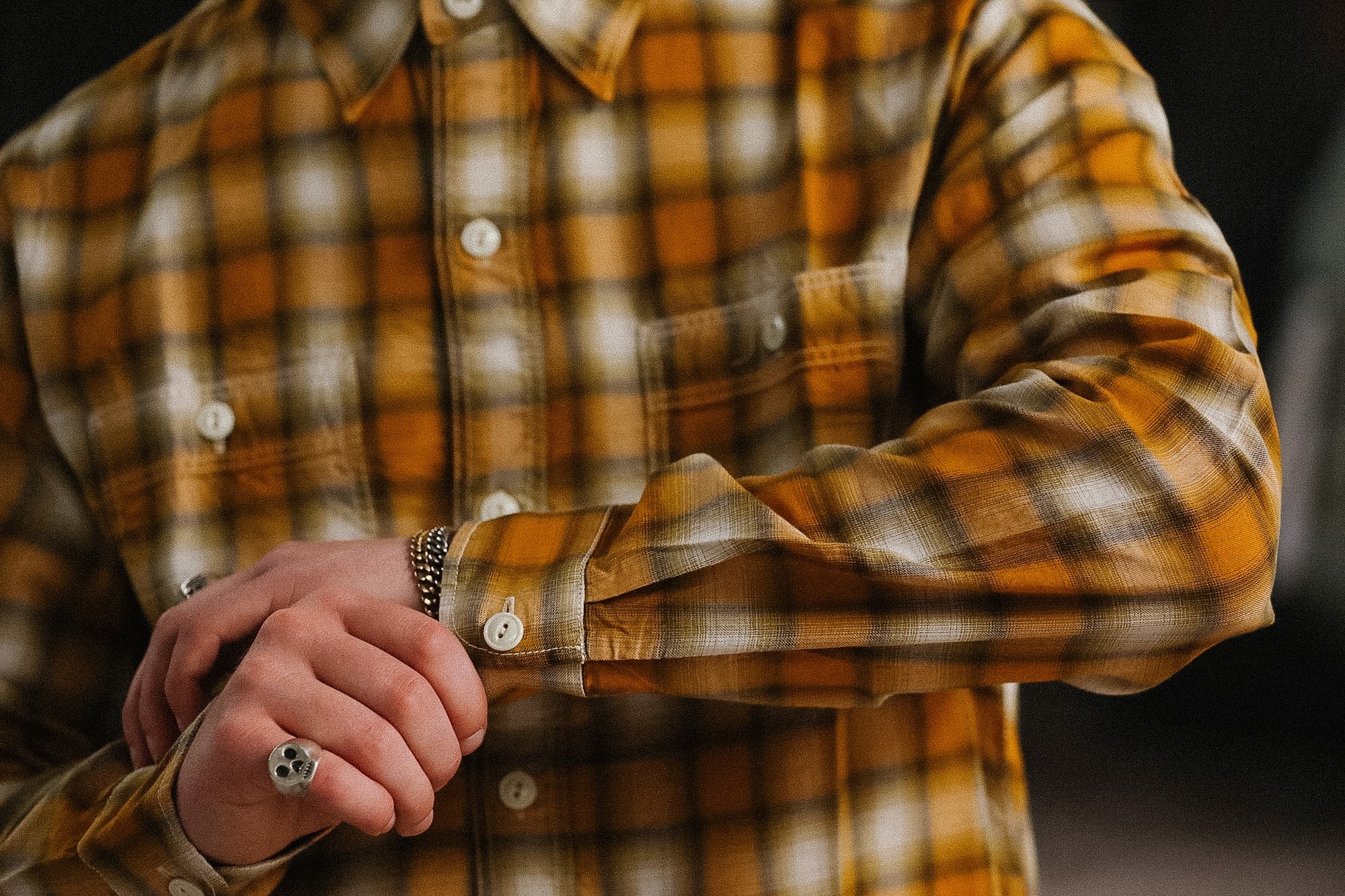 Close-up of a person wearing a plaid shirt with a blurred background