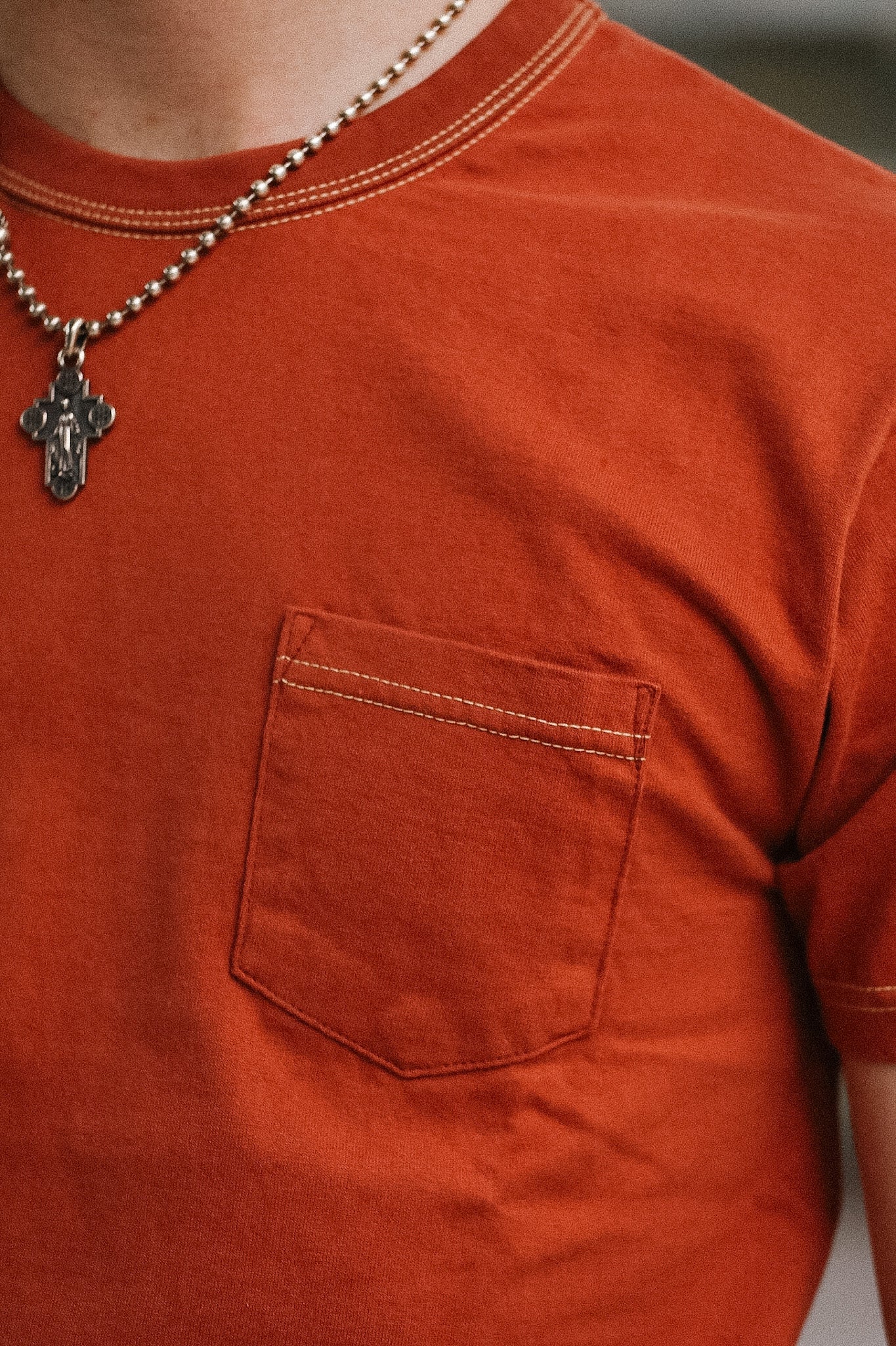 man wearing orange t-shirt on blurred background 