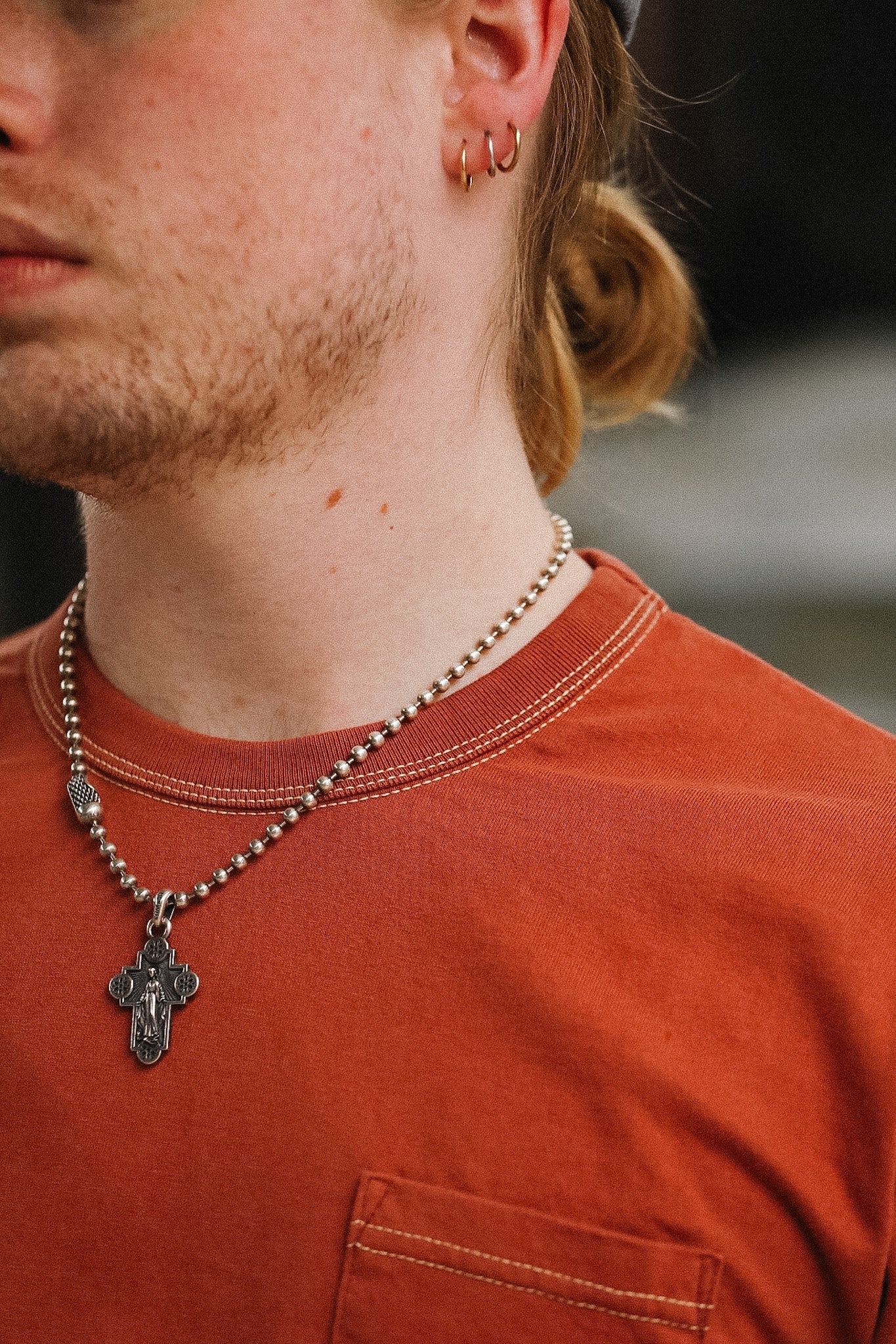 man wearing orange t-shirt on blurred background 