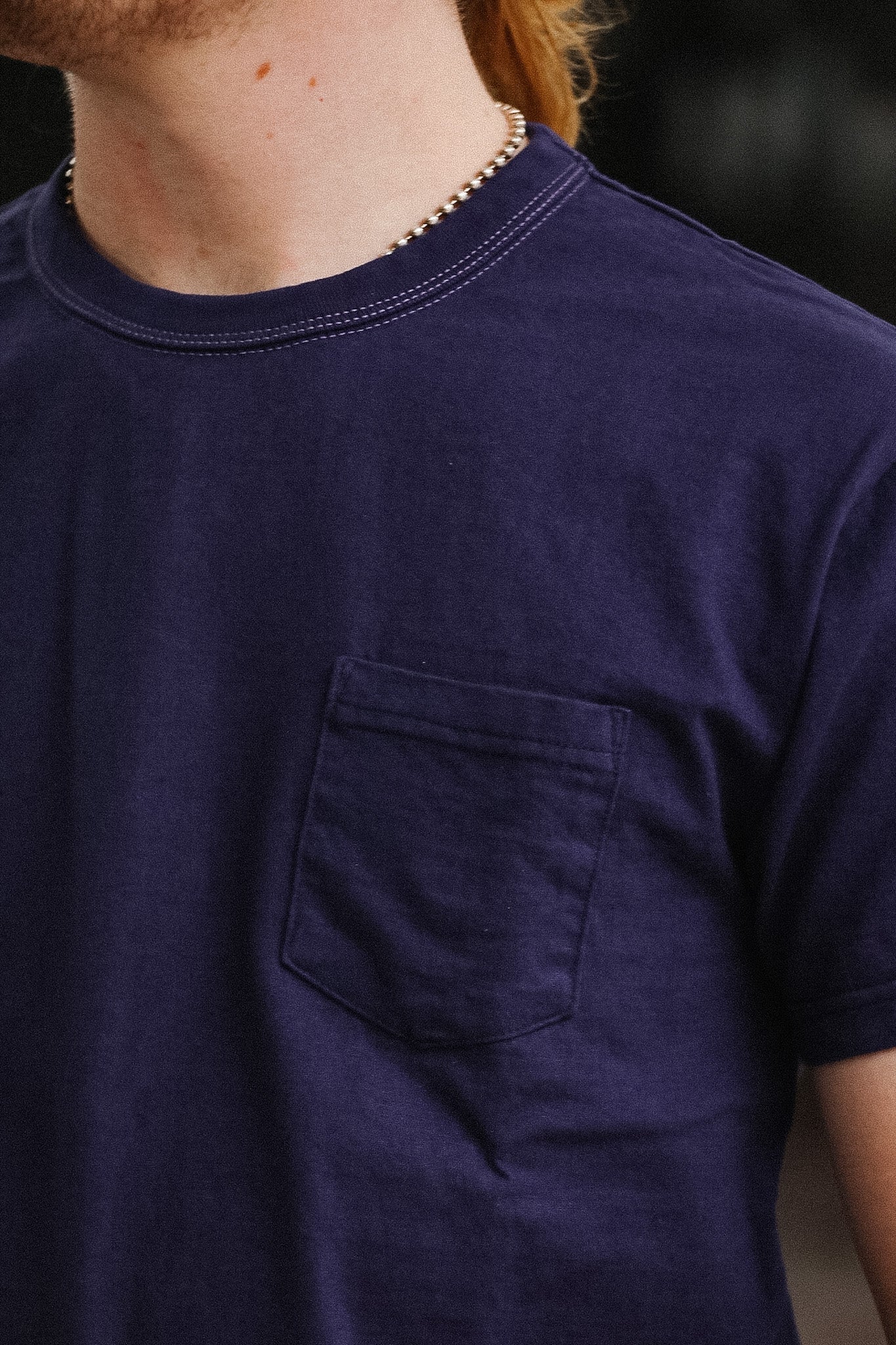 man wearing purple t-shirt on blurred background 