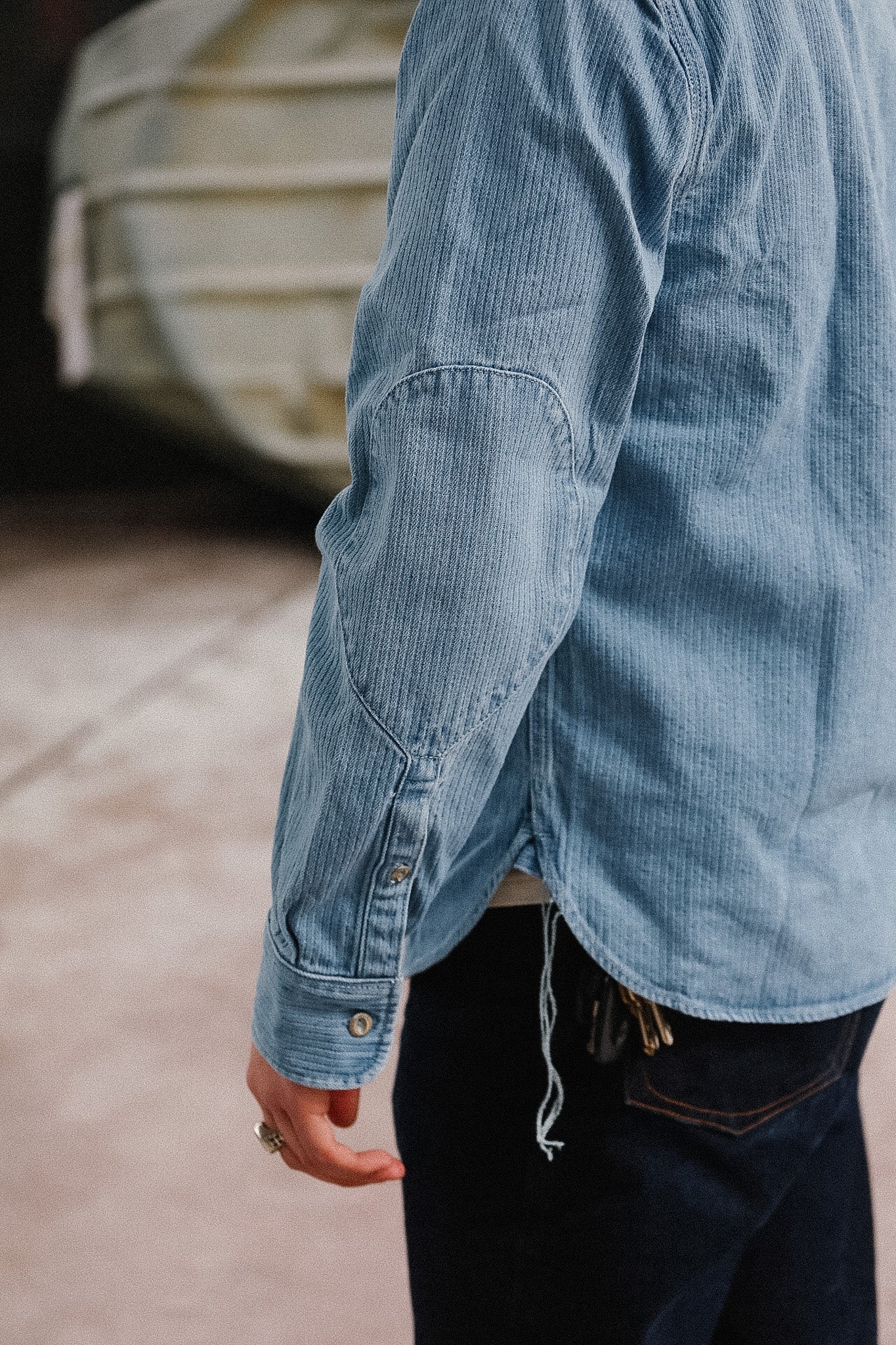 Person wearing a light blue denim jacket with a blurred background