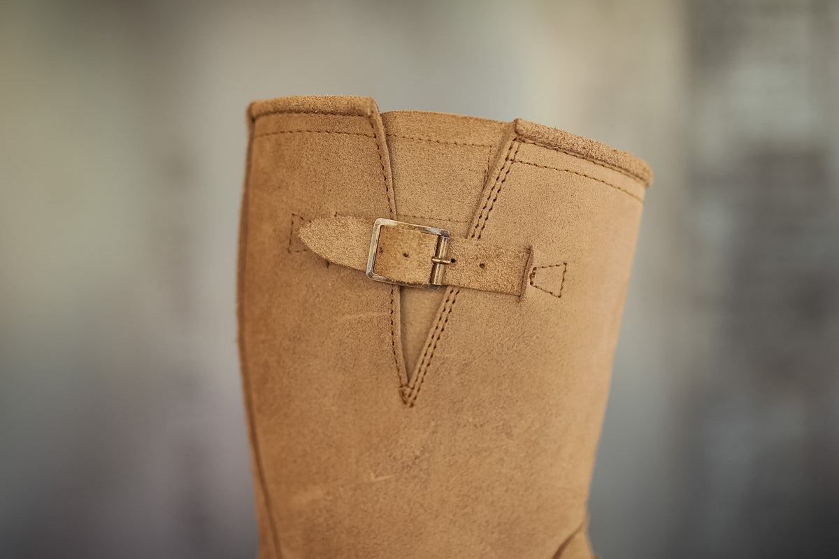 Brown boot with a buckle on a blurred background