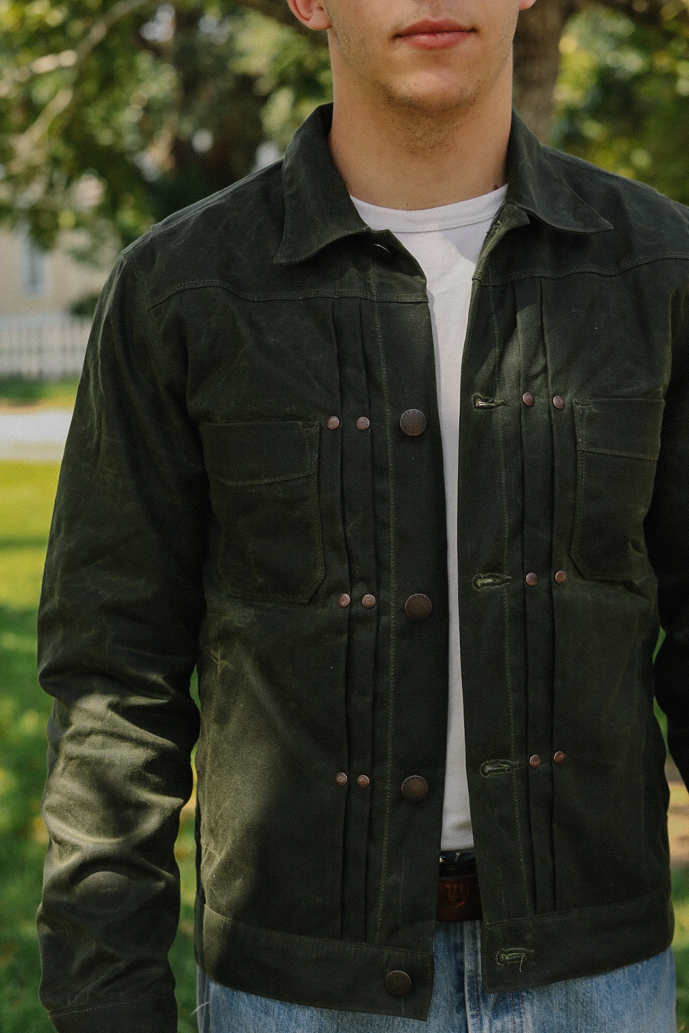 Man wearing dark green rugged work jacket with button closure and chest pockets outdoors