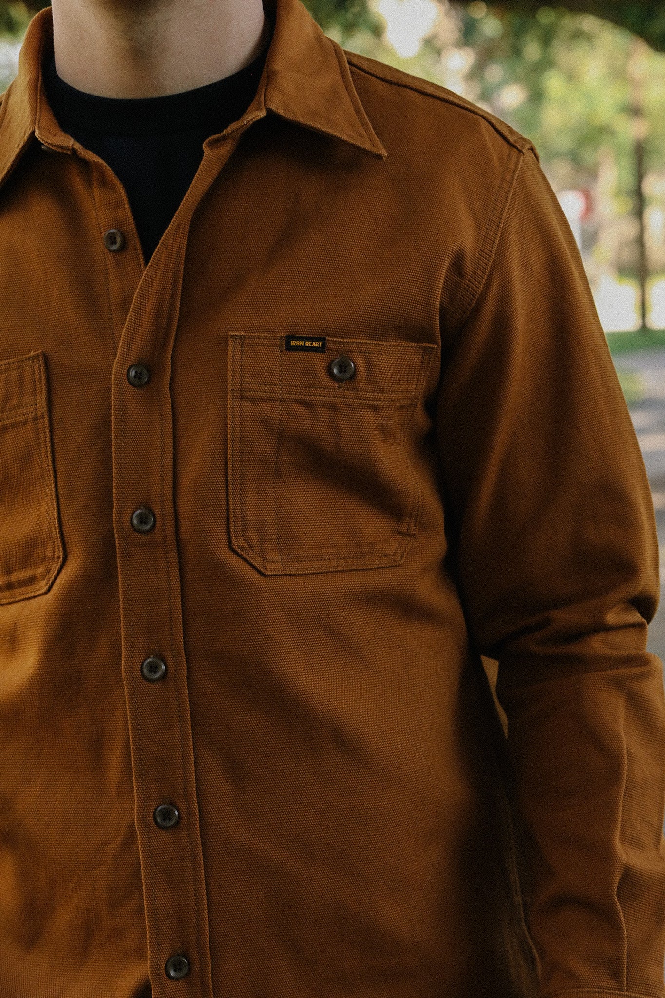 Close-up of man wearing brown Iron Heart button-up work shirt with chest pockets outside