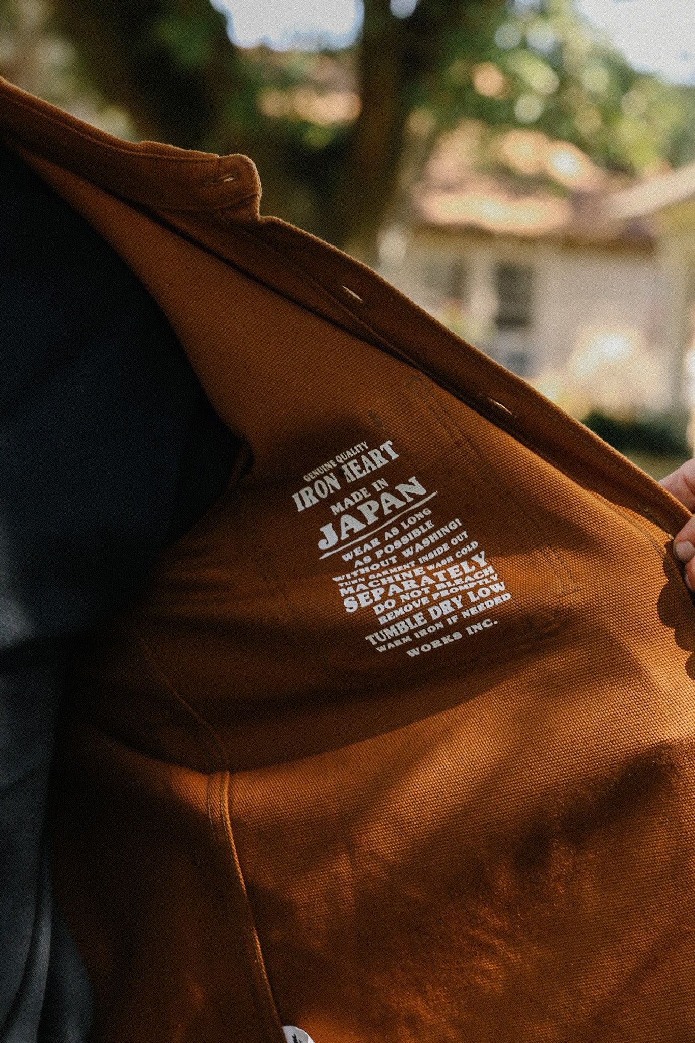 Close-up of brown Iron Heart jacket interior label showing care instructions and Made in Japan text