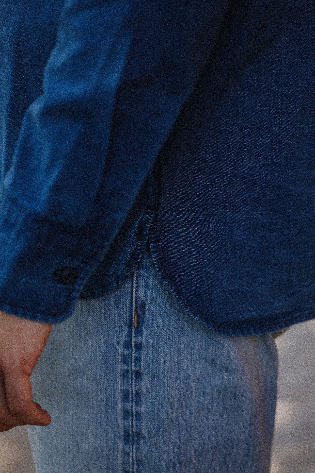 Close-up of person wearing dark blue denim shirt and light blue jeans, casual apparel from Iron Shop Provisions