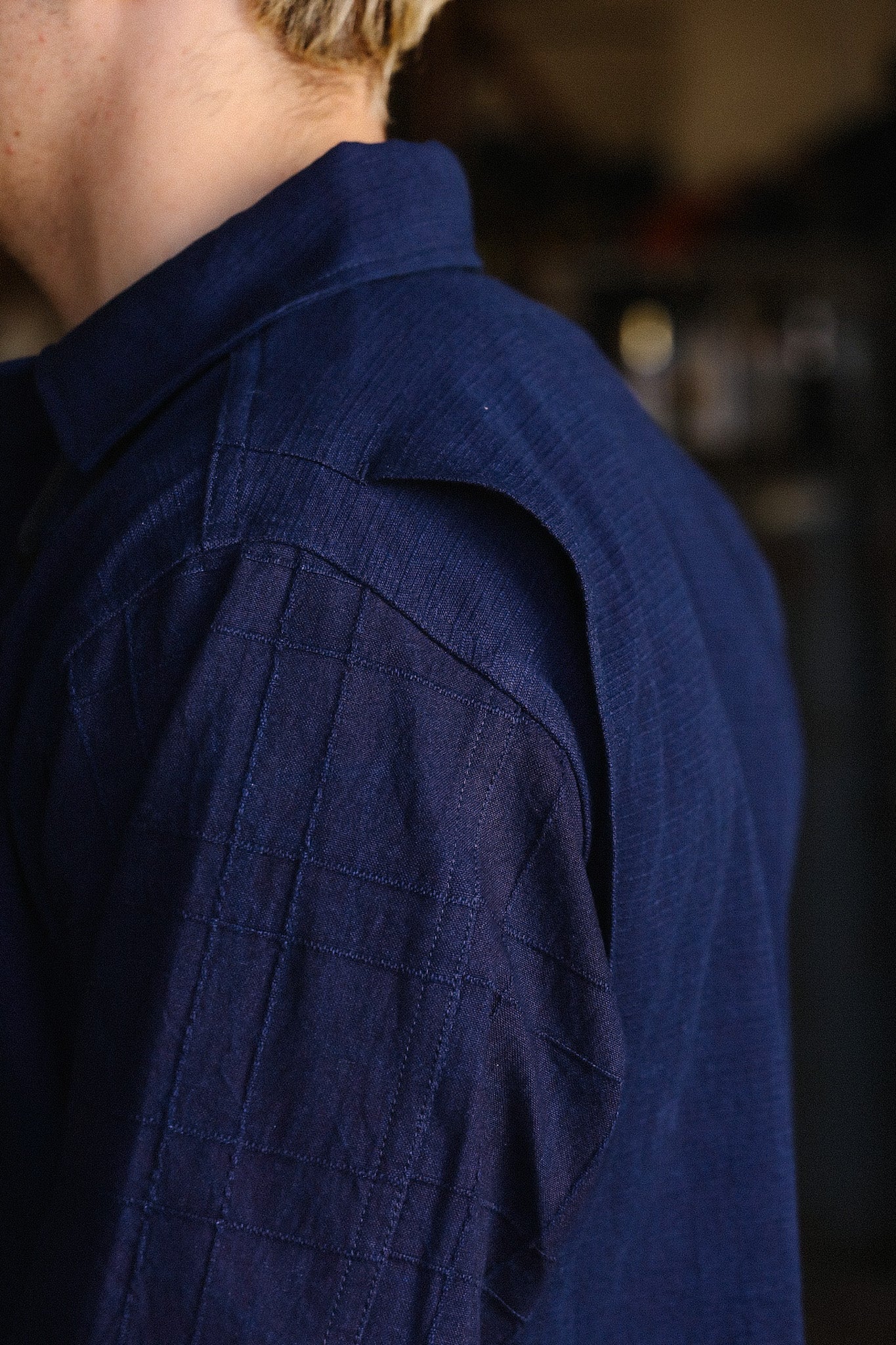 Close-up of a navy blue quilted shoulder detail on a long-sleeve shirt from Iron Shop Provisions