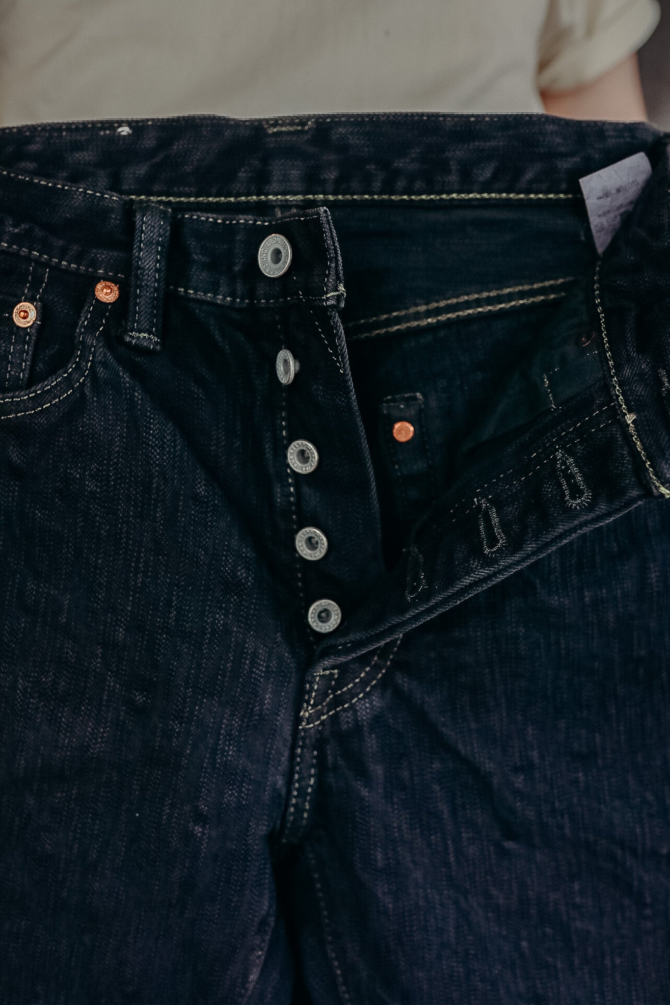 Dark denim jeans with button fly detailing and visible stitching from Iron Shop Provisions