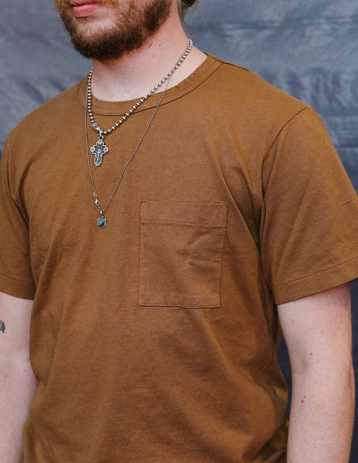 man wearing brown t-shirt with a pocket
