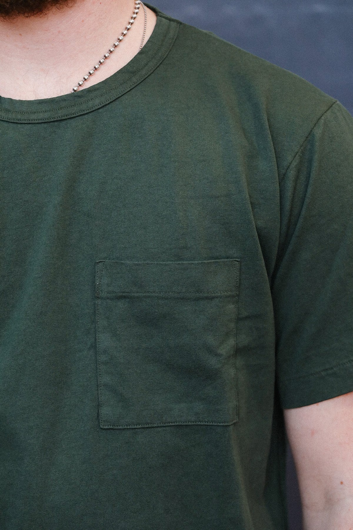 man wearing green t-shirt with a pocket