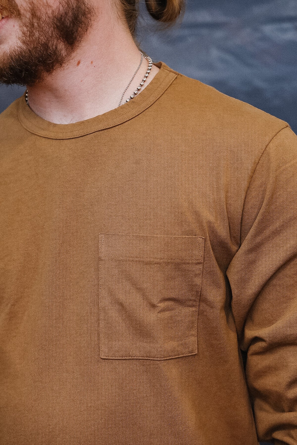 close up detail of brown long sleeve t-shirt