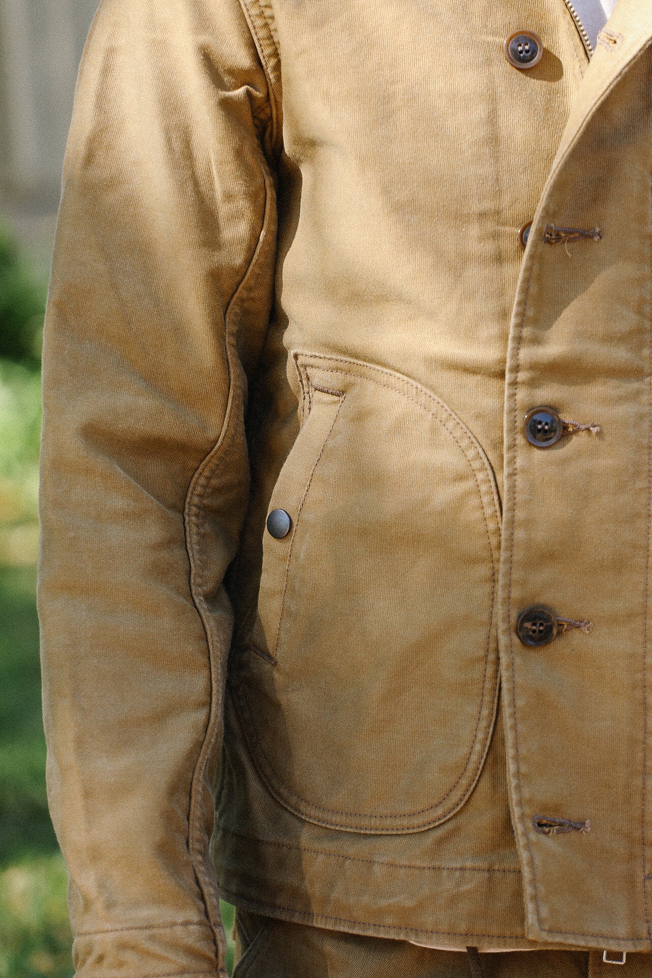 Close-up of durable tan work jacket pocket and button details from Iron Shop Provisions