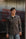 man wearing brown shirt standing in front of metal gate