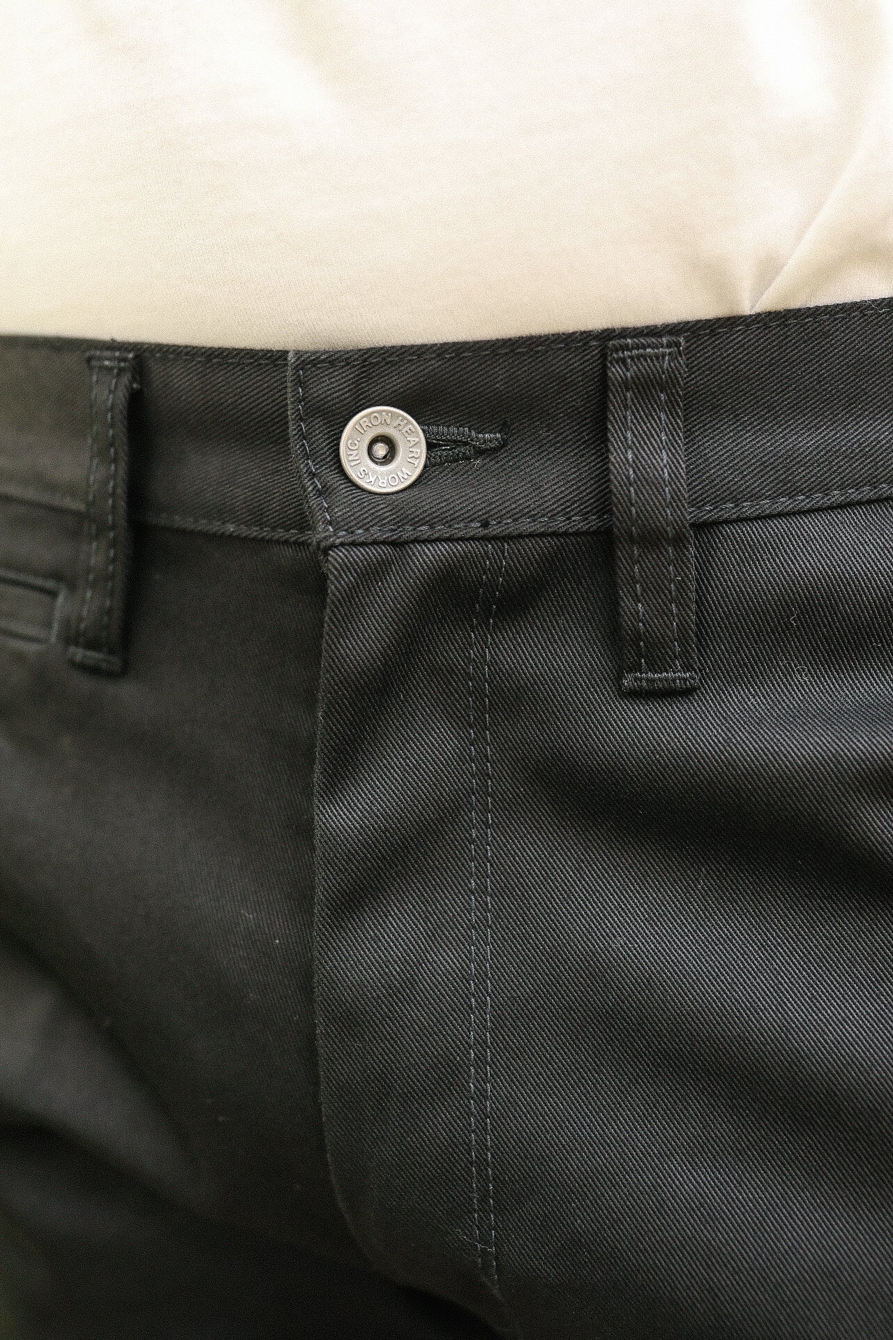 Close-up of black Iron Heart pants waistband with metal button and belt loop