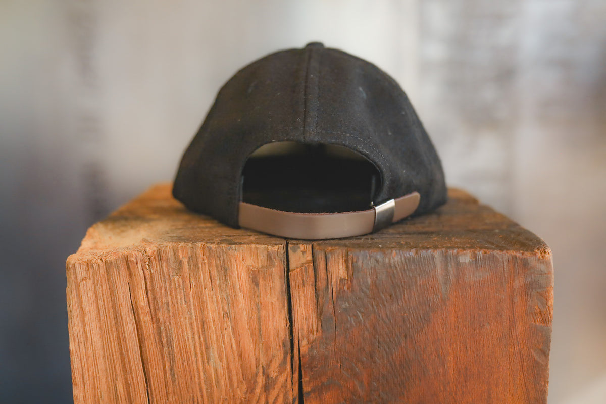 Up close of a black baseball cap on wood block 