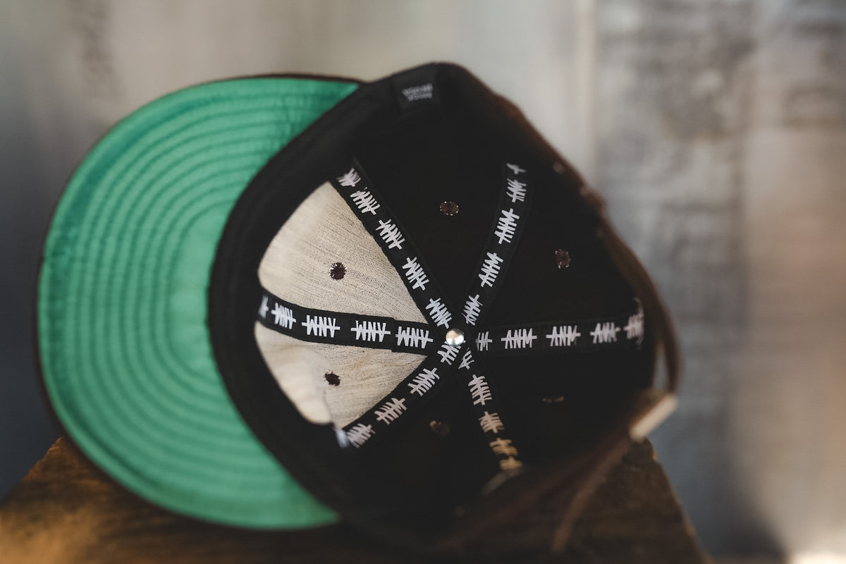 Up close of a brown baseball cap with branding 