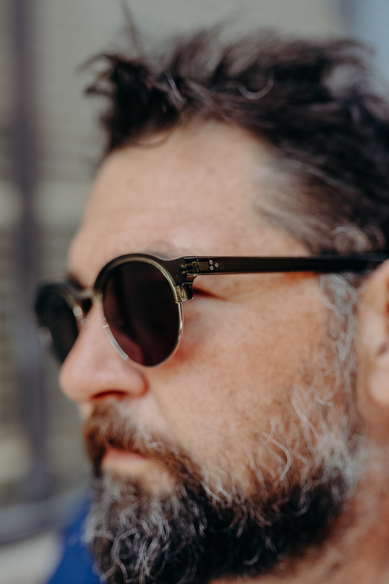 Close-up of man with dark sunglasses and salt-and-pepper beard, casual outdoor portrait