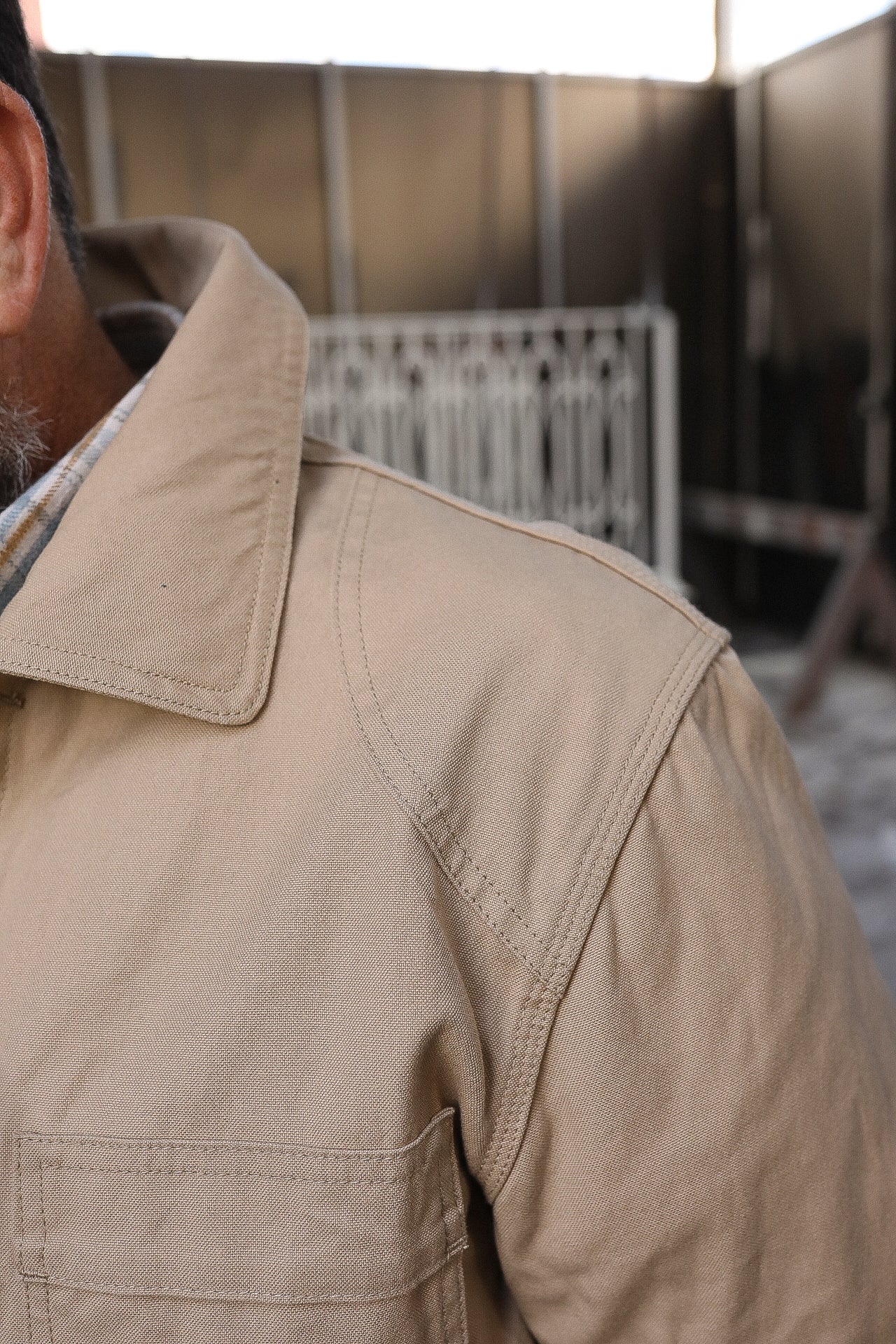Close-up of a tan durable work jacket shoulder and collar with detailed stitching from Iron Shop Provisions