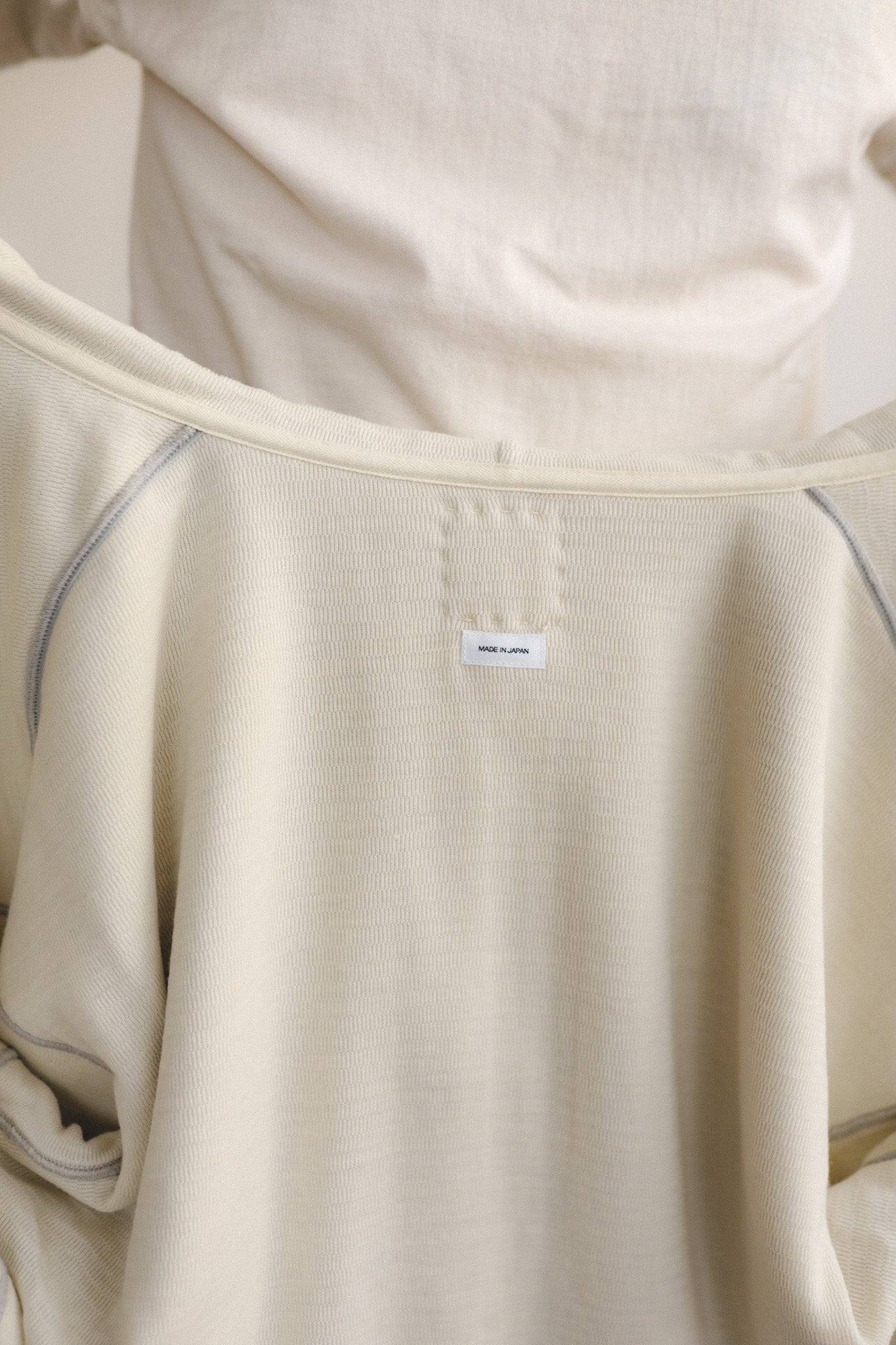 Close-up of beige fabric with a small label on a neutral background