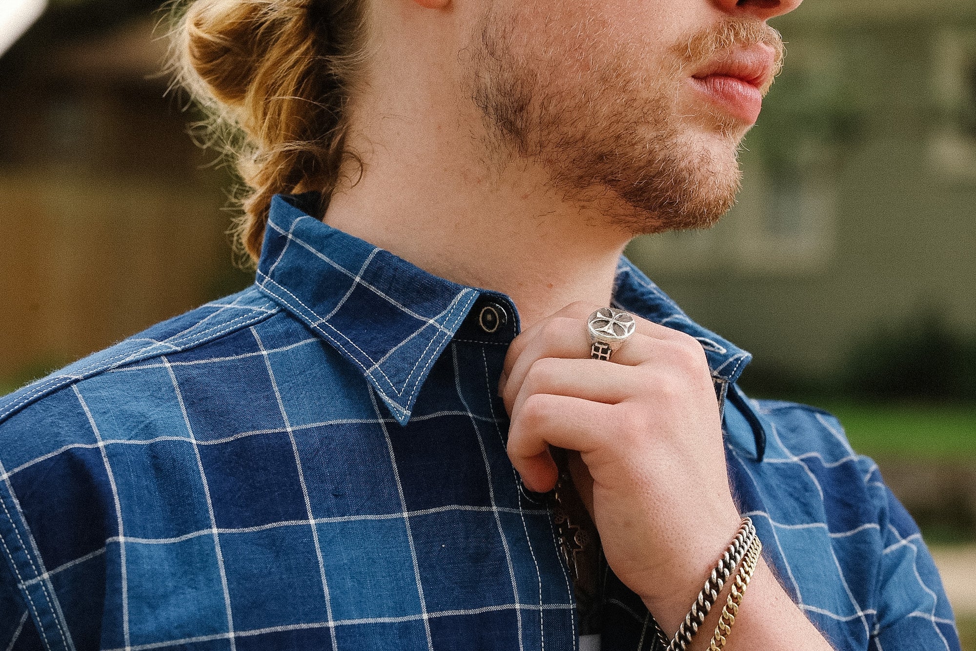 Man wearing a blue plaid shirt with a blurred background