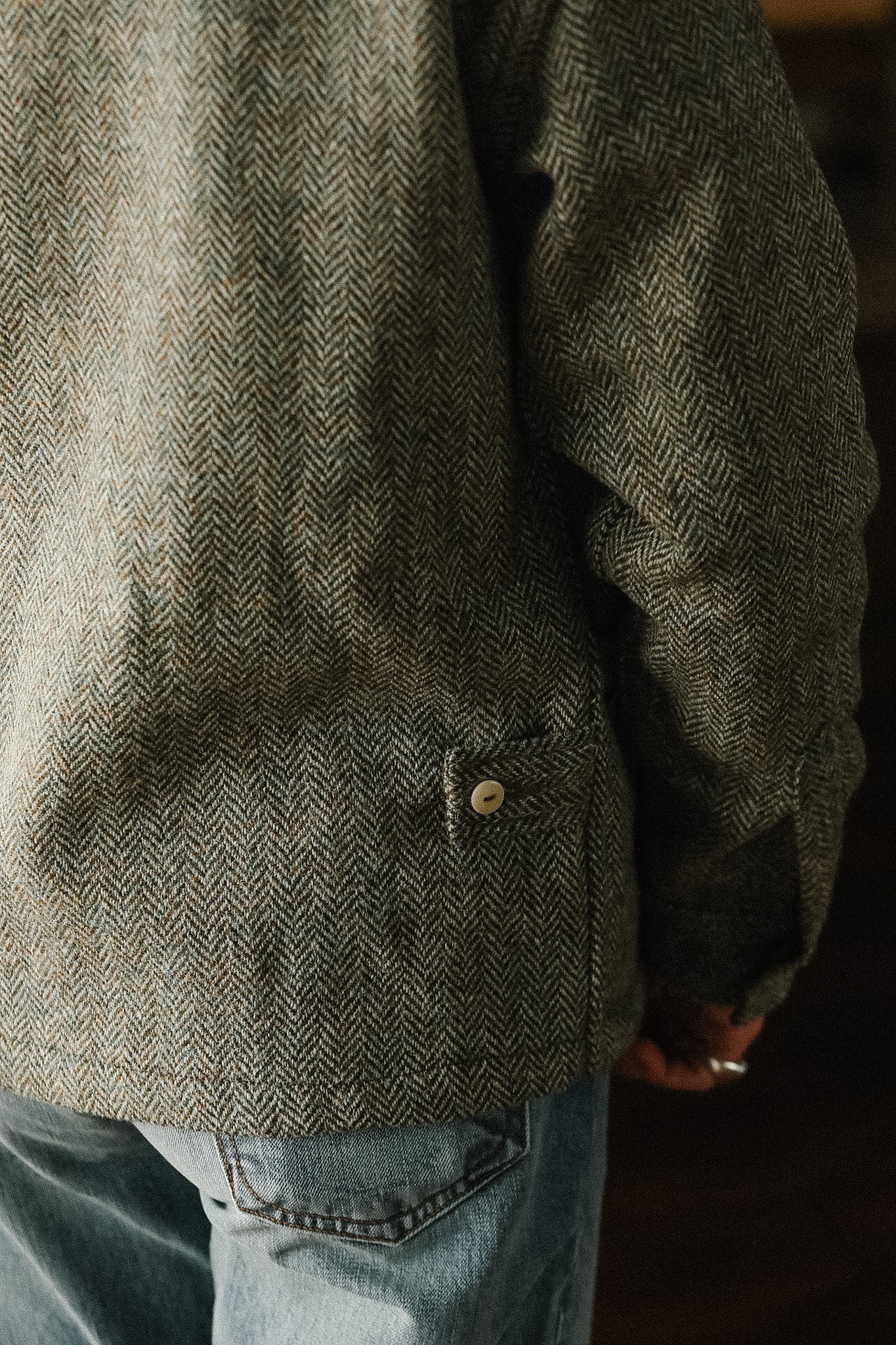 Person wearing a textured green jacket with a blurred background