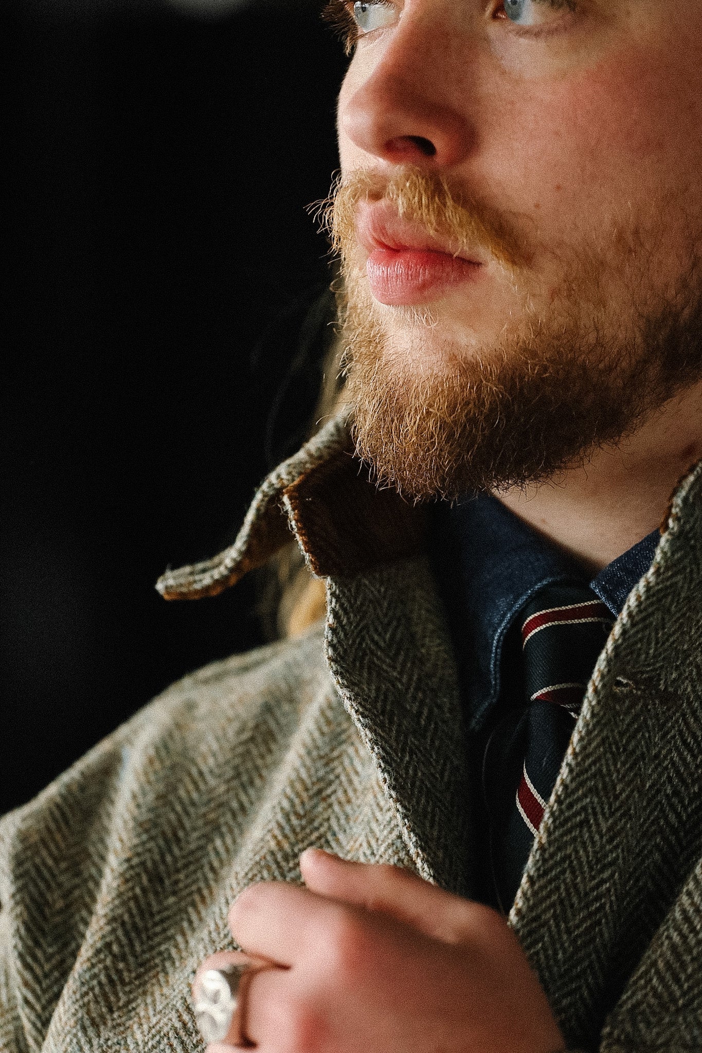 Man wearing a textured jacket with a dark background