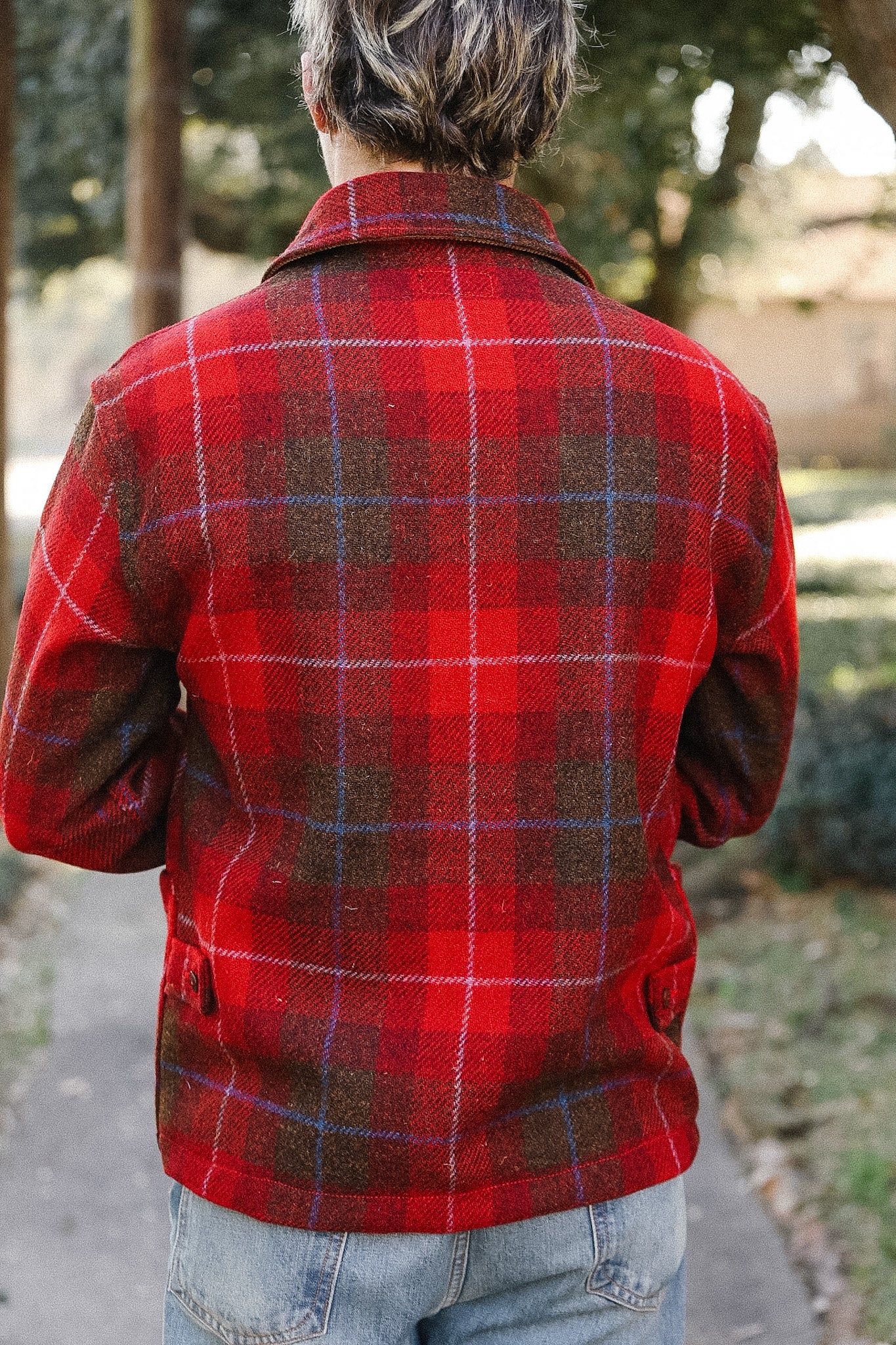 Person wearing a red plaid jacket in an outdoor setting