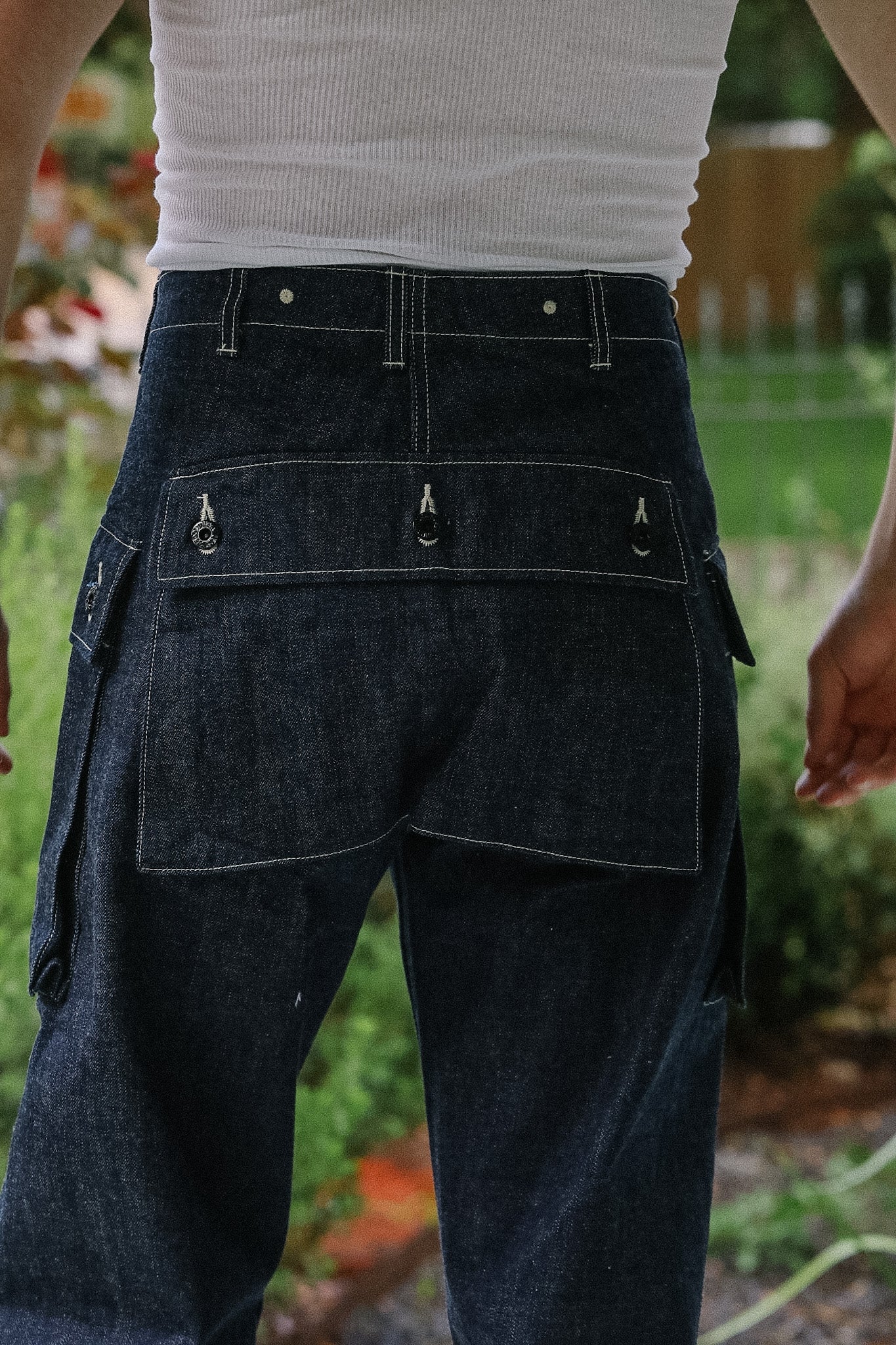 Person wearing dark blue cargo pants with multiple pockets in an outdoor setting.