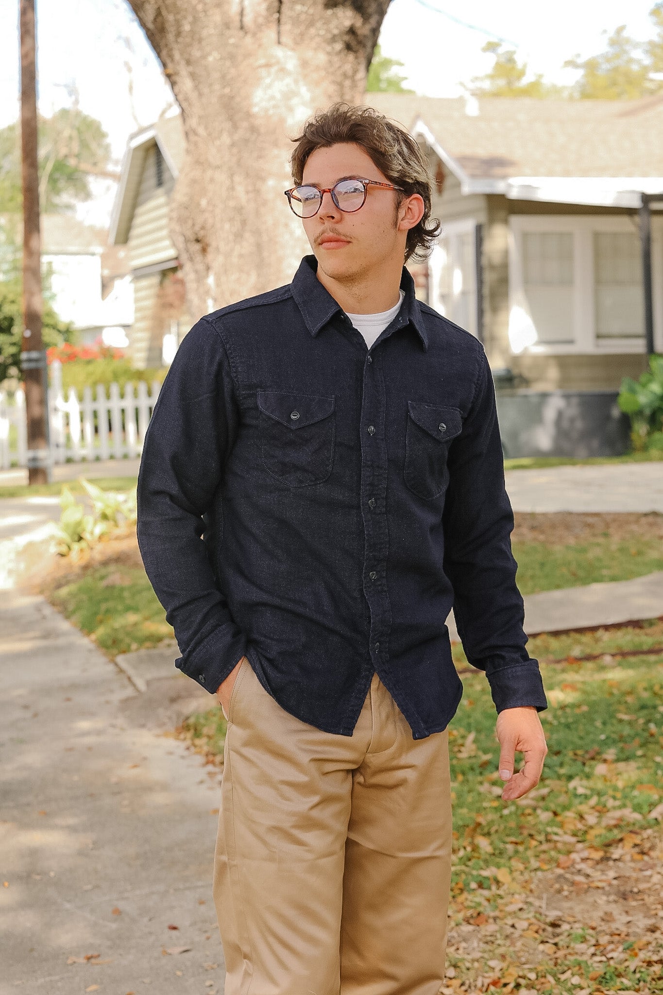 man wearing dark blue shirt on sidewalk