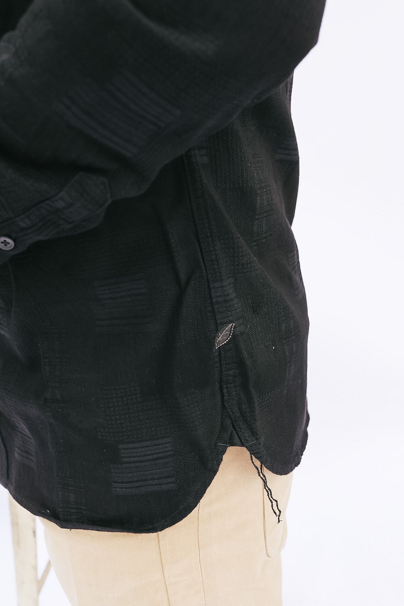 Black distressed denim jacket on a white background
