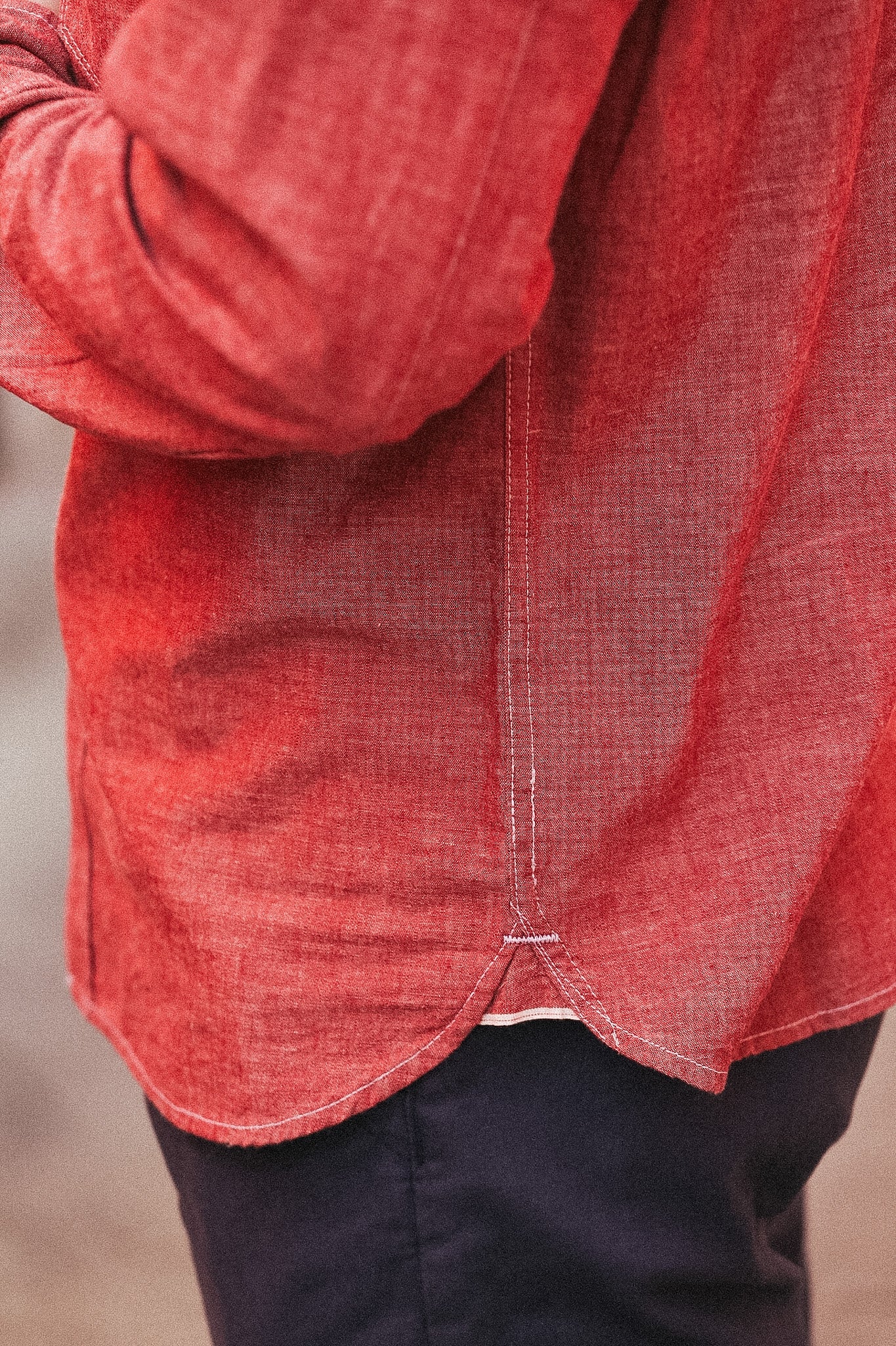 Red textured shirt worn by a person with a blurred background