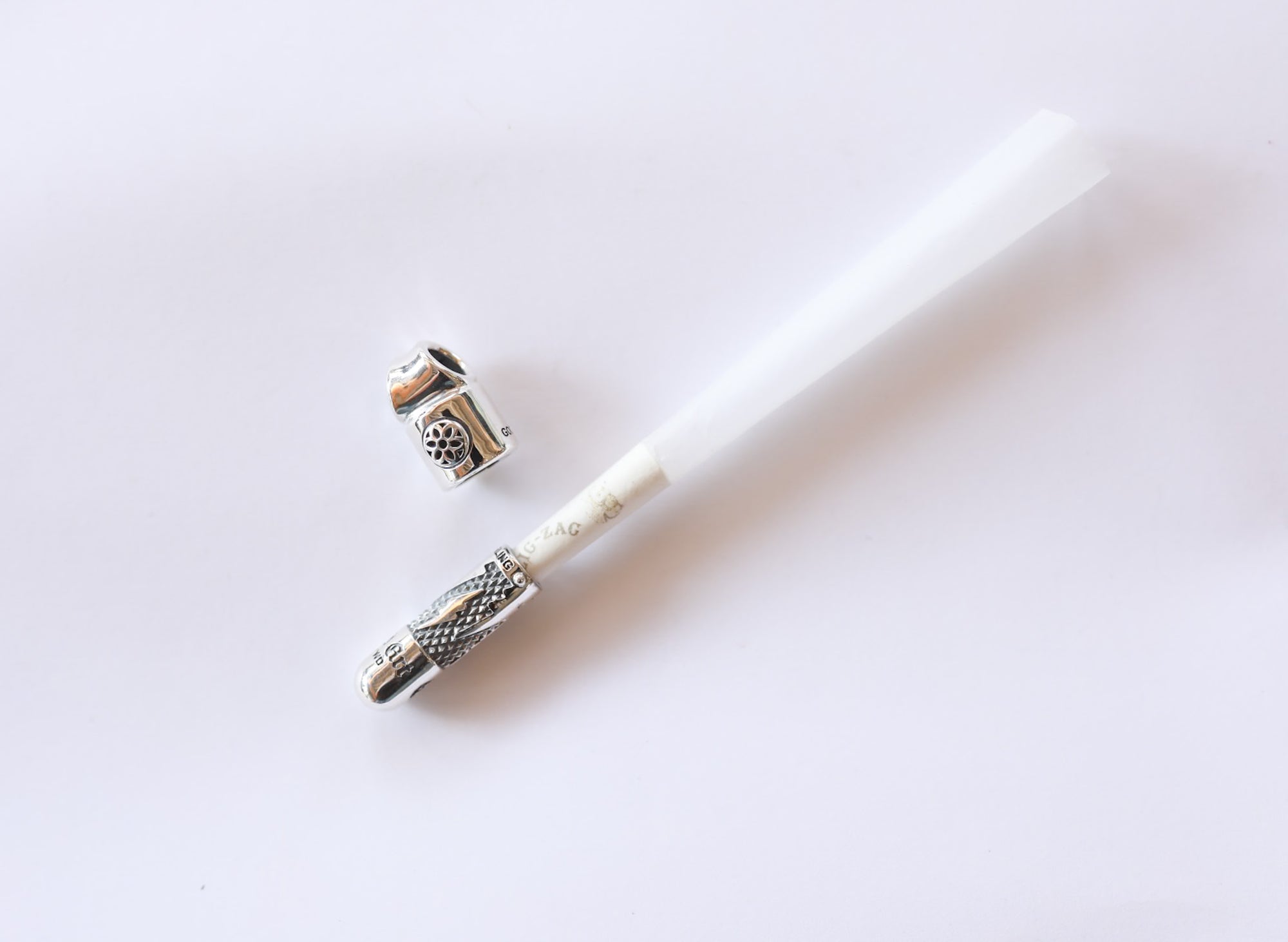 Silver metal cigarette holder with detachable cap on white background, Iron Shop Provisions