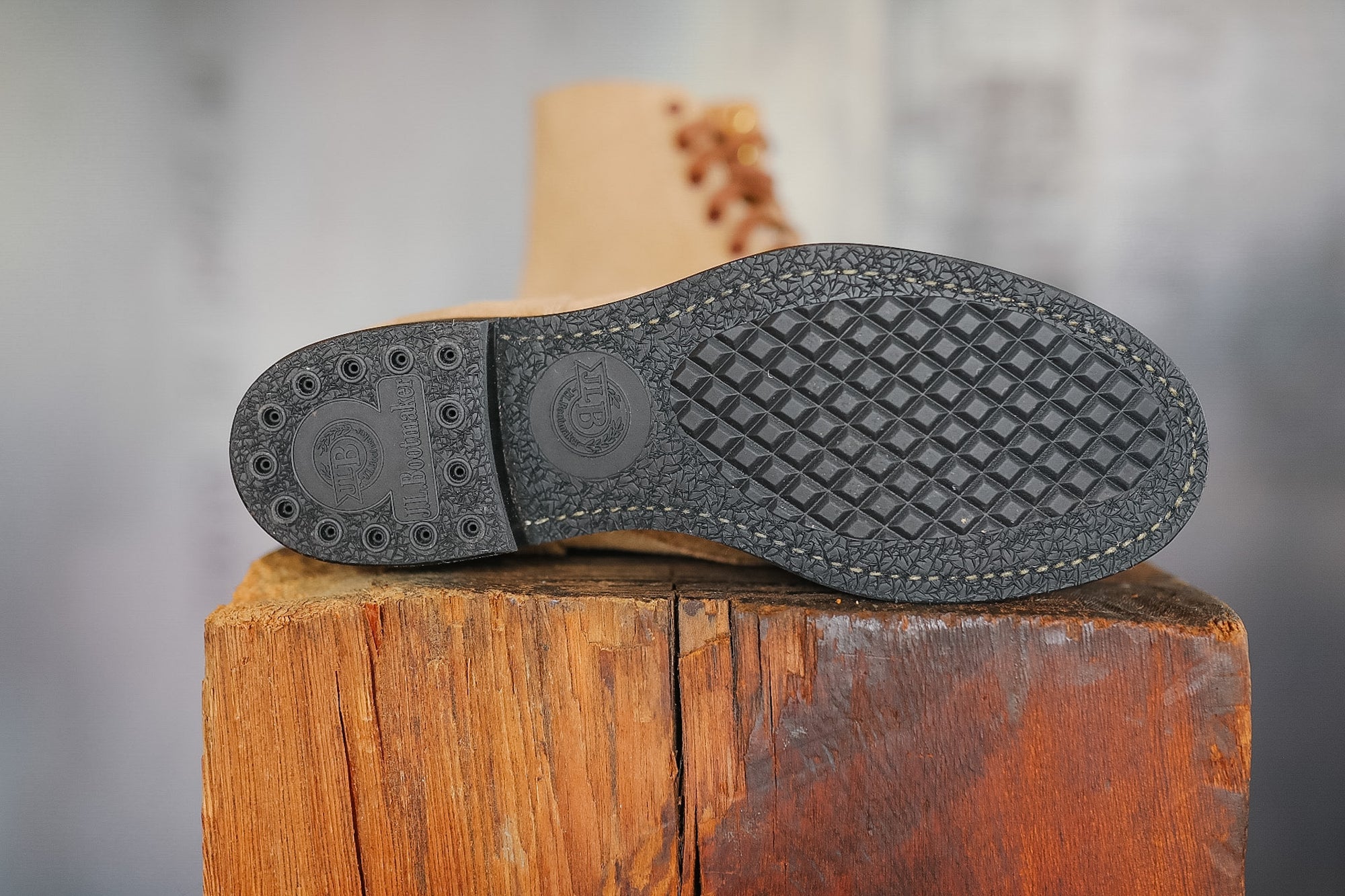 Gray shoe sole on a wooden block with a blurred background