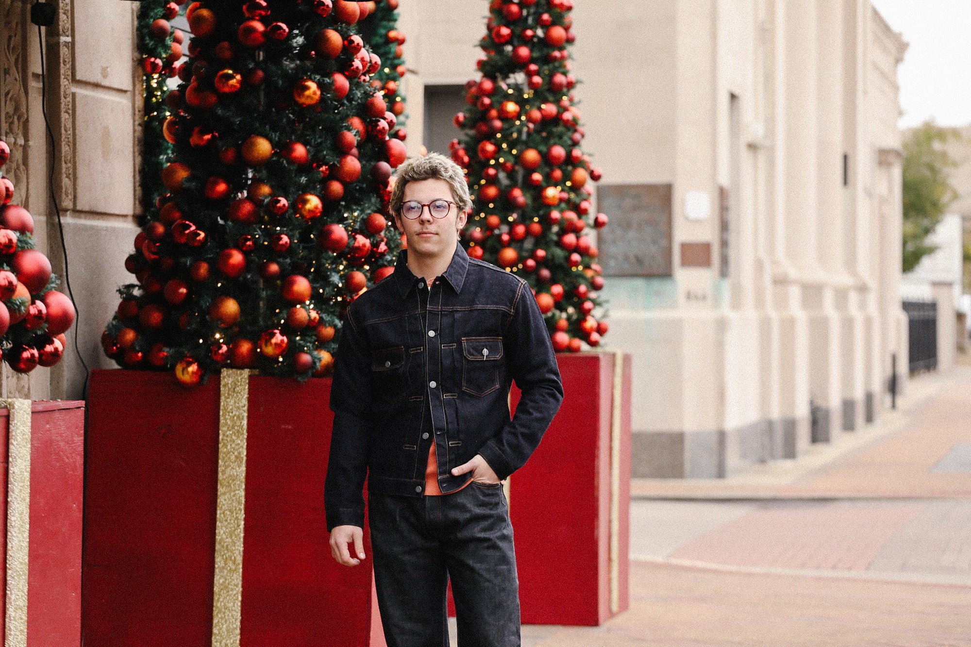 Person standing in front of Christmas decorations on a city street