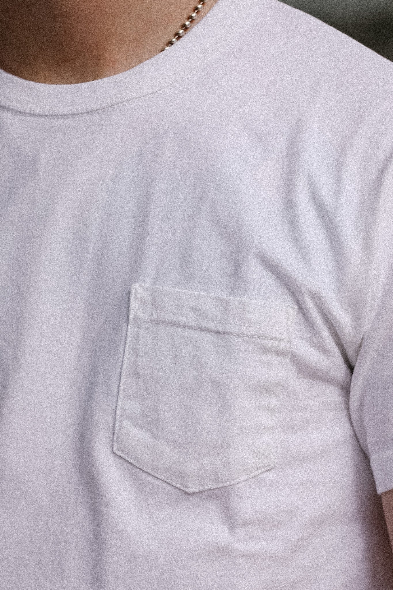 Close-up of a light gray t-shirt with a pocket