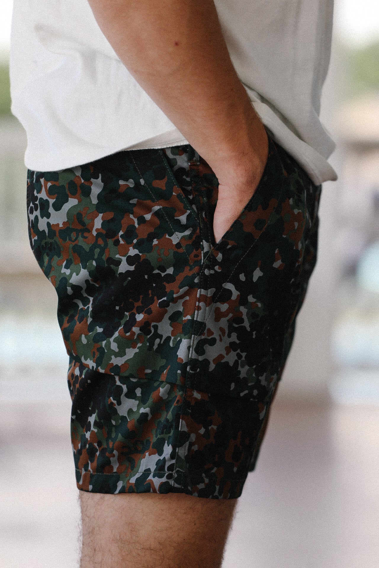Side view of men's fatigue shorts in diffusion camo print worn with white t-shirt