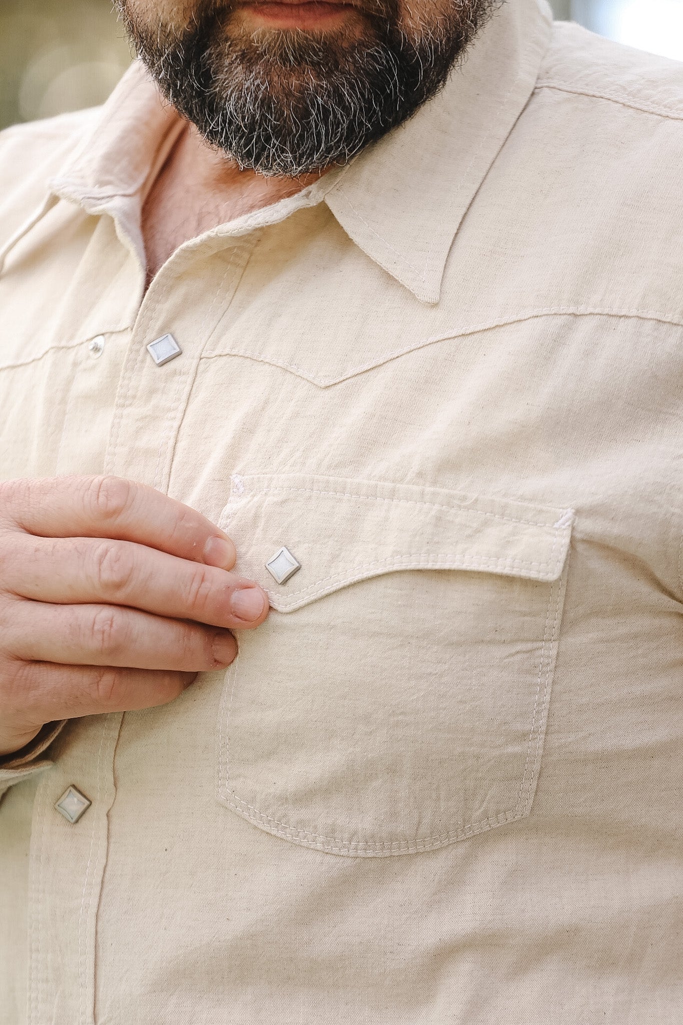 Close-up of a beige shirt with buttons and a pocket