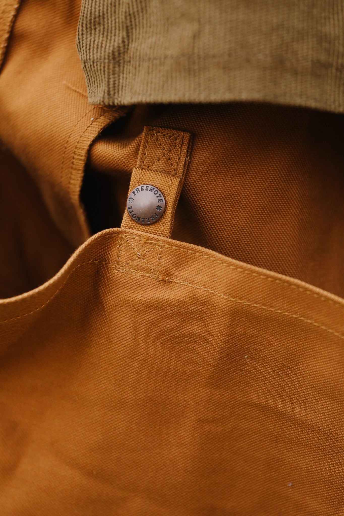 Close-up of a brown fabric with a button and stitching detail