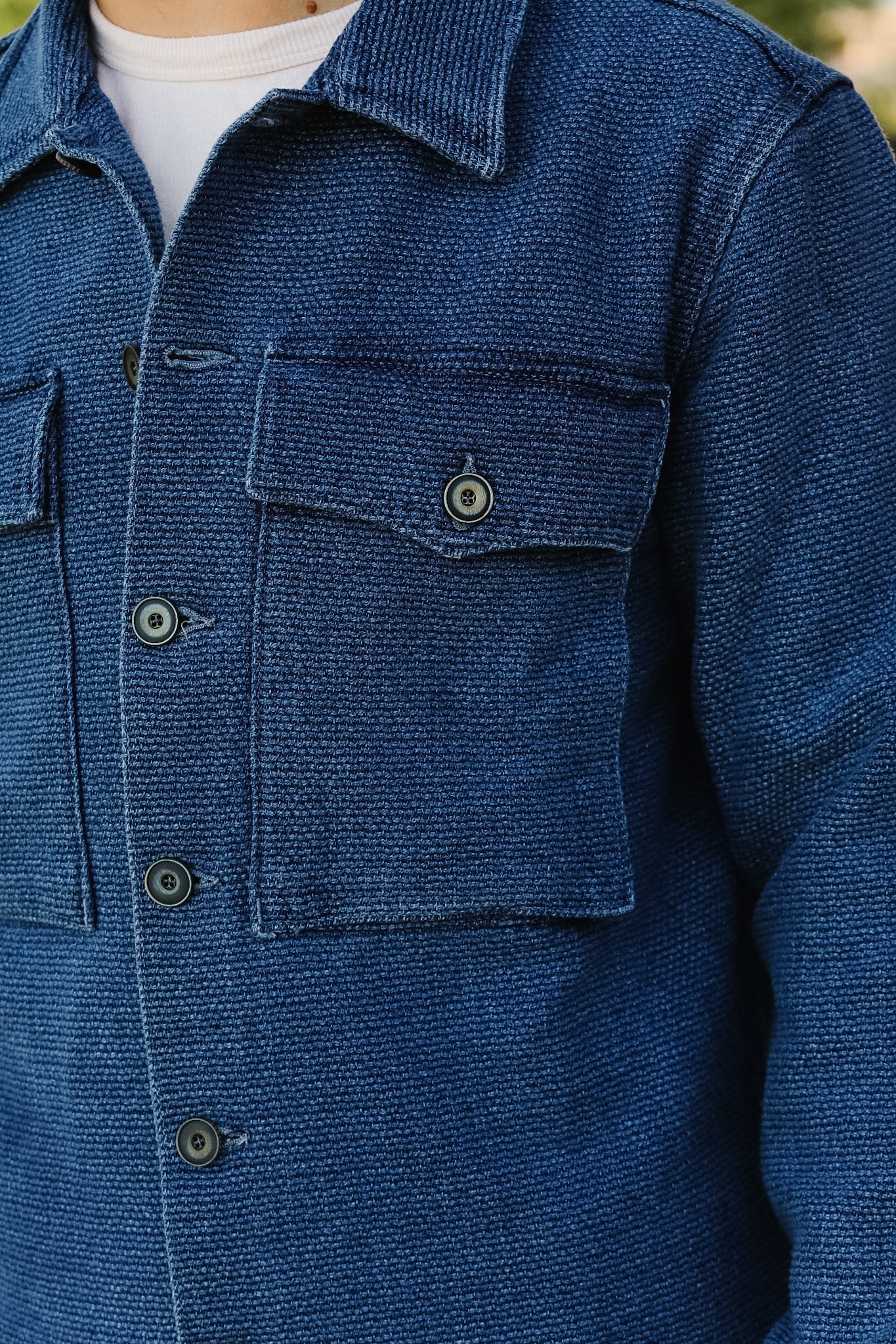 Close-up of a blue textured jacket with buttons