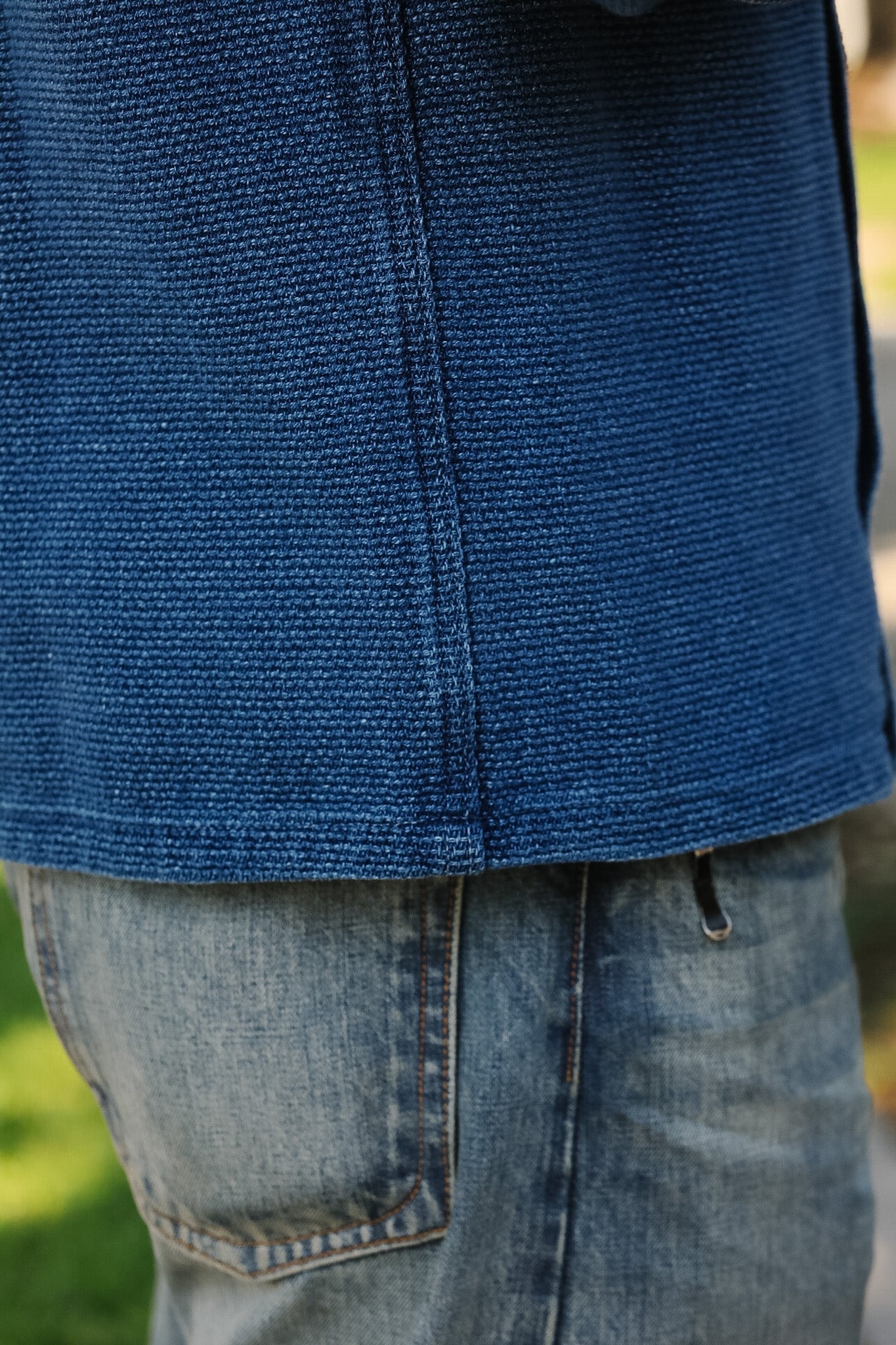 Close-up of a blue jacket and jeans with a blurred background