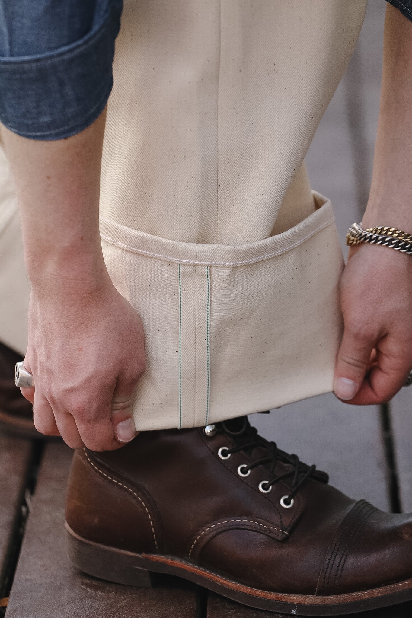 Person wearing beige pants and brown boots with a blurred background