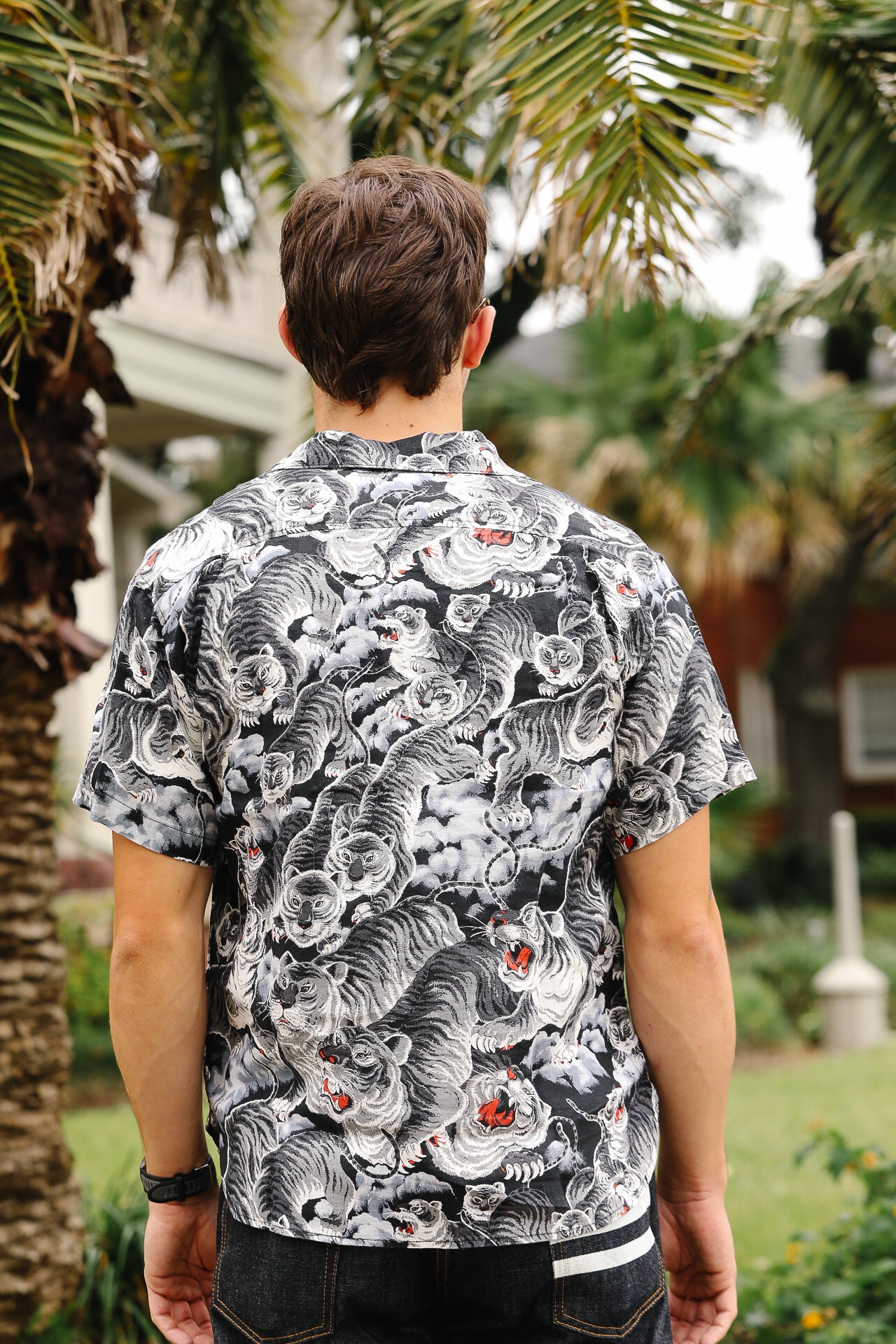 Person wearing a black and white patterned shirt with tigers outdoors