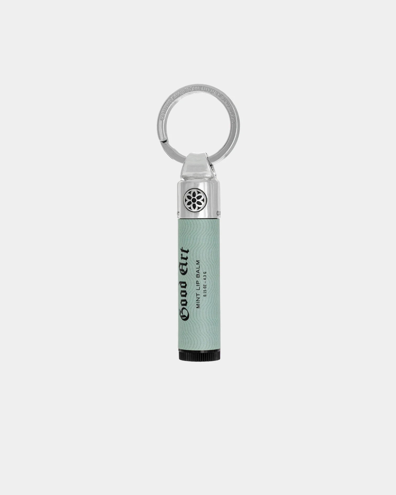 Good Art mint lip balm with sterling silver bomb cap keychain accessory on white background