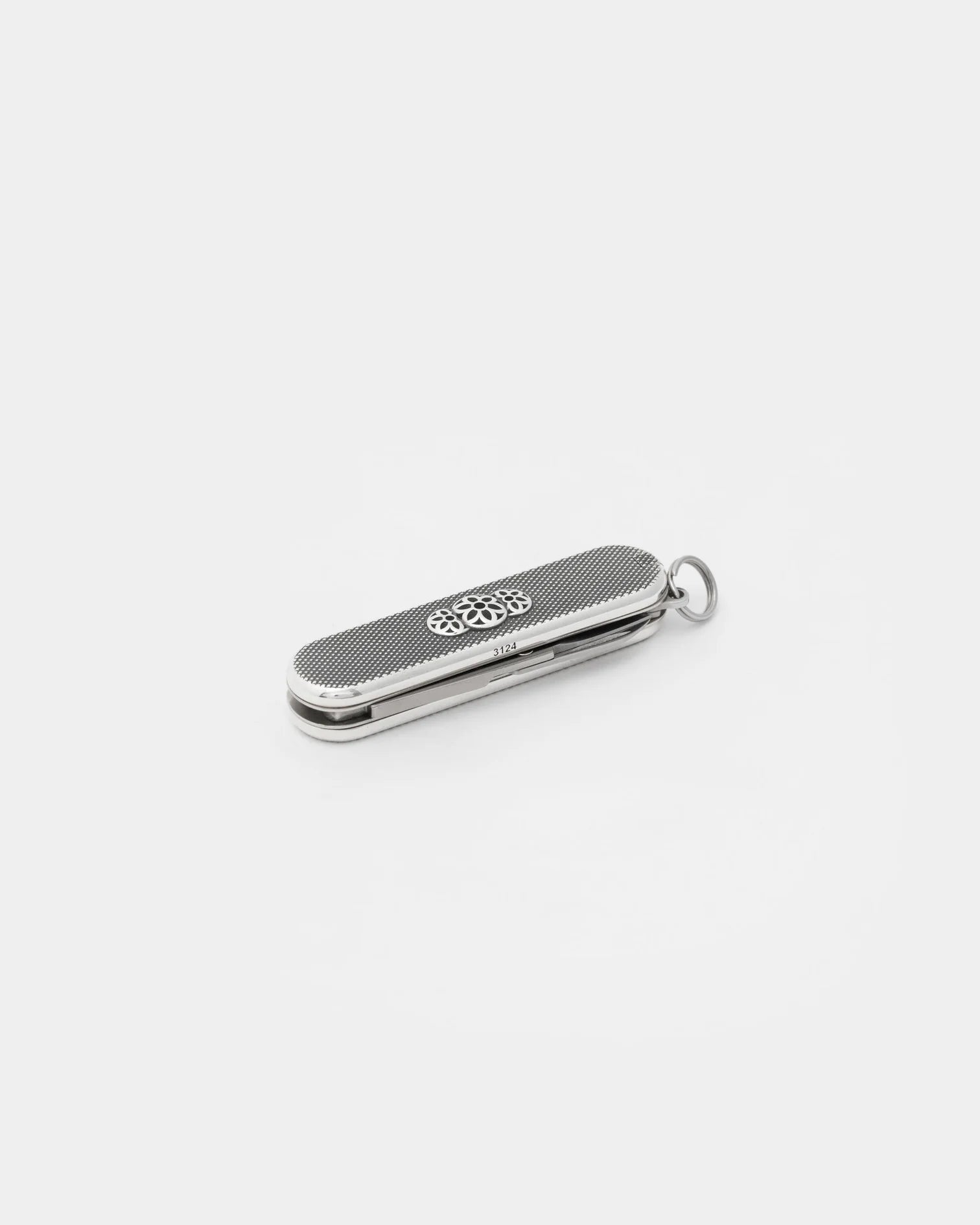 Sterling silver folding pocket knife with textured handle and decorative emblem, isolated on white