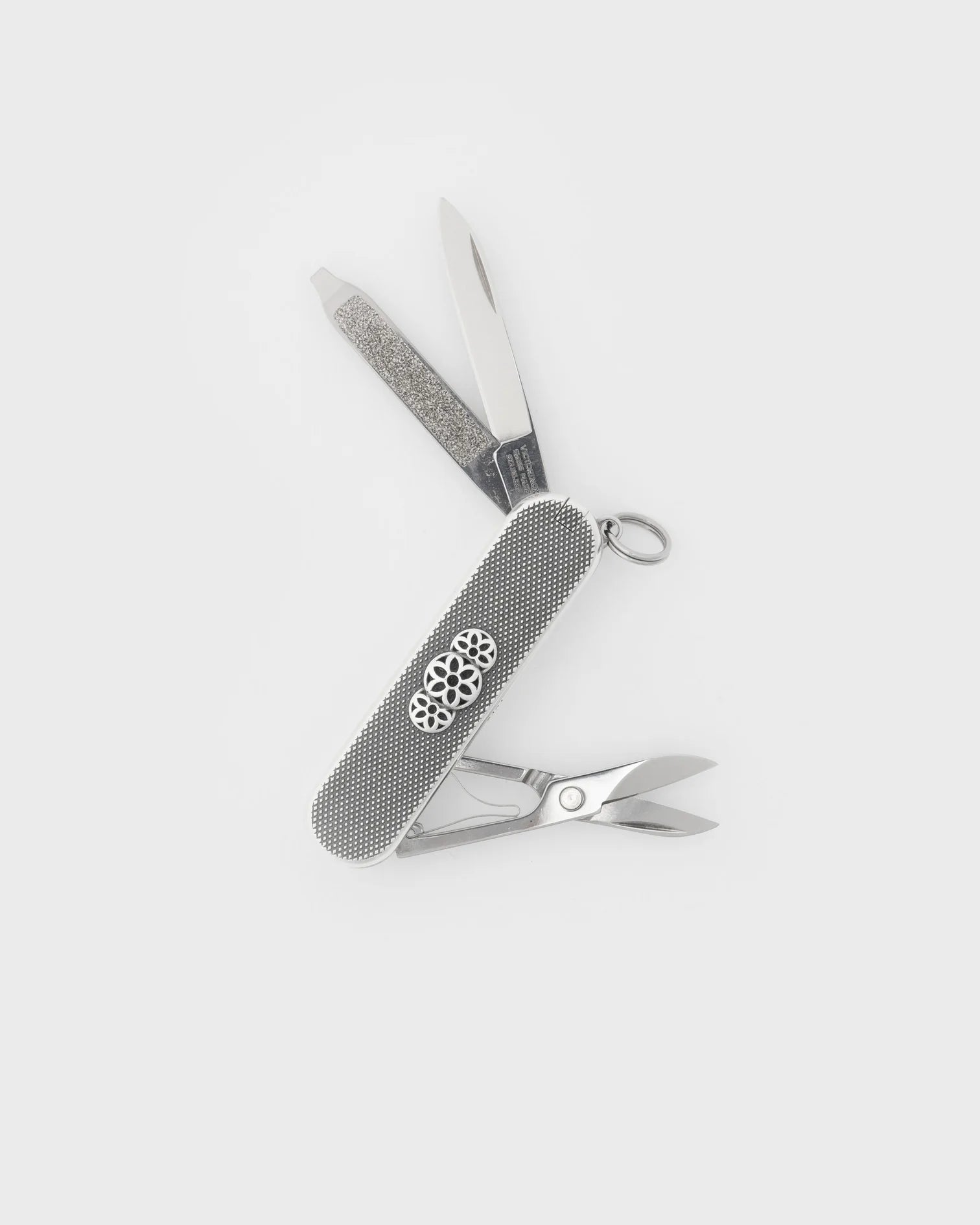 Sterling silver multi-tool pocket knife with nail file, blade, and scissors on white background