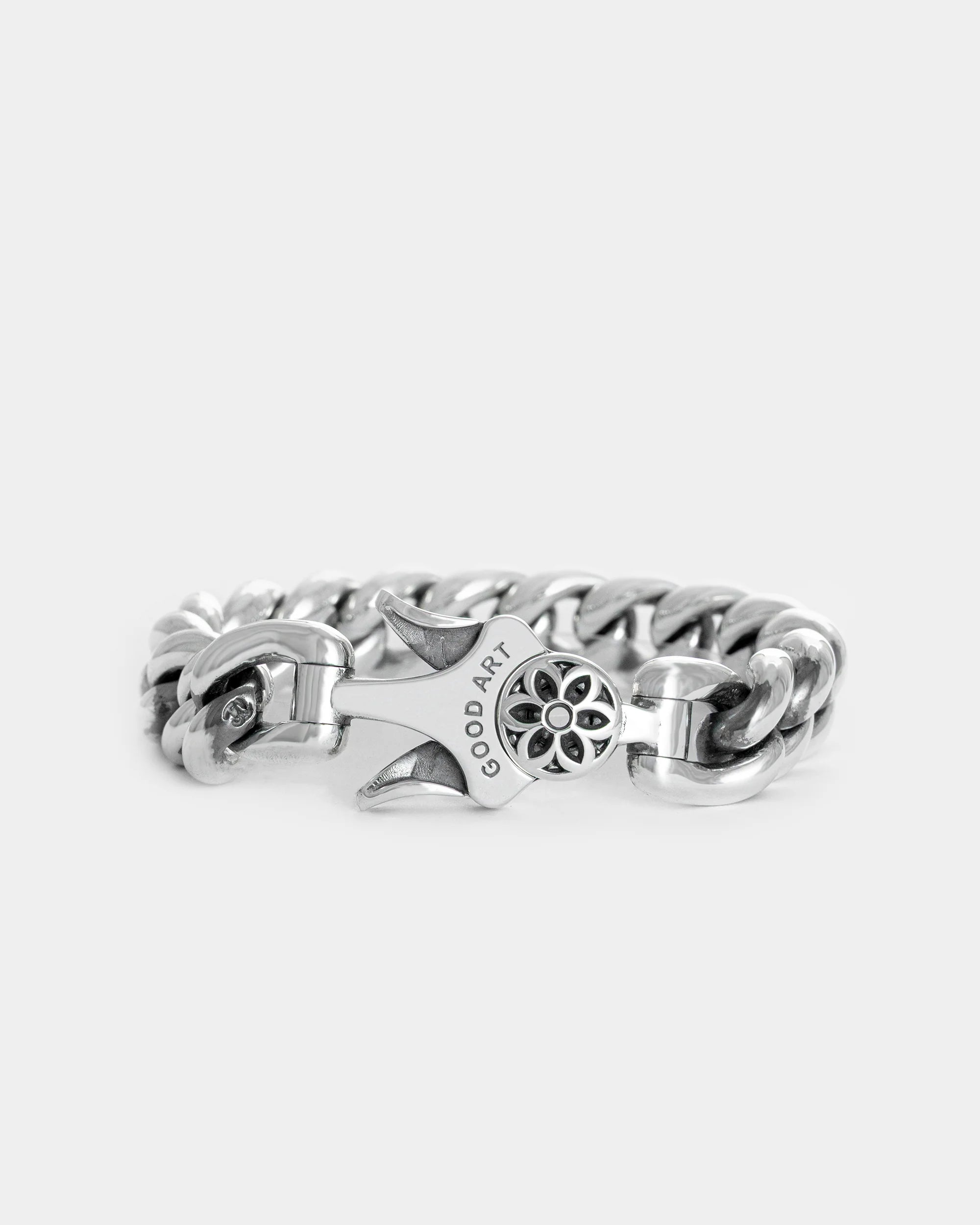 Sterling silver chain bracelet with GOOD ART engraving and floral clasp detail on white background