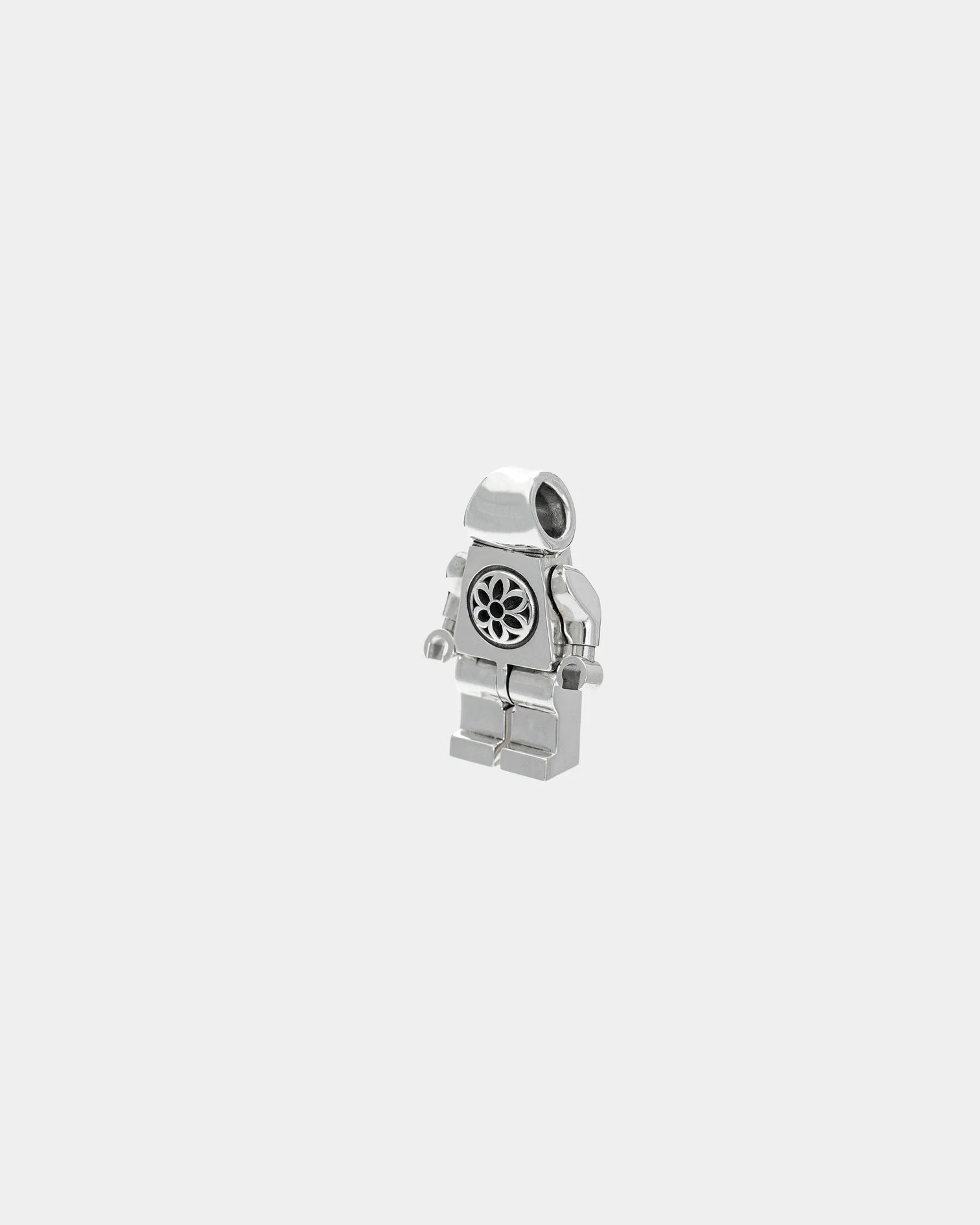 Sterling silver small robot figurine with floral circular design on torso, plain gray background