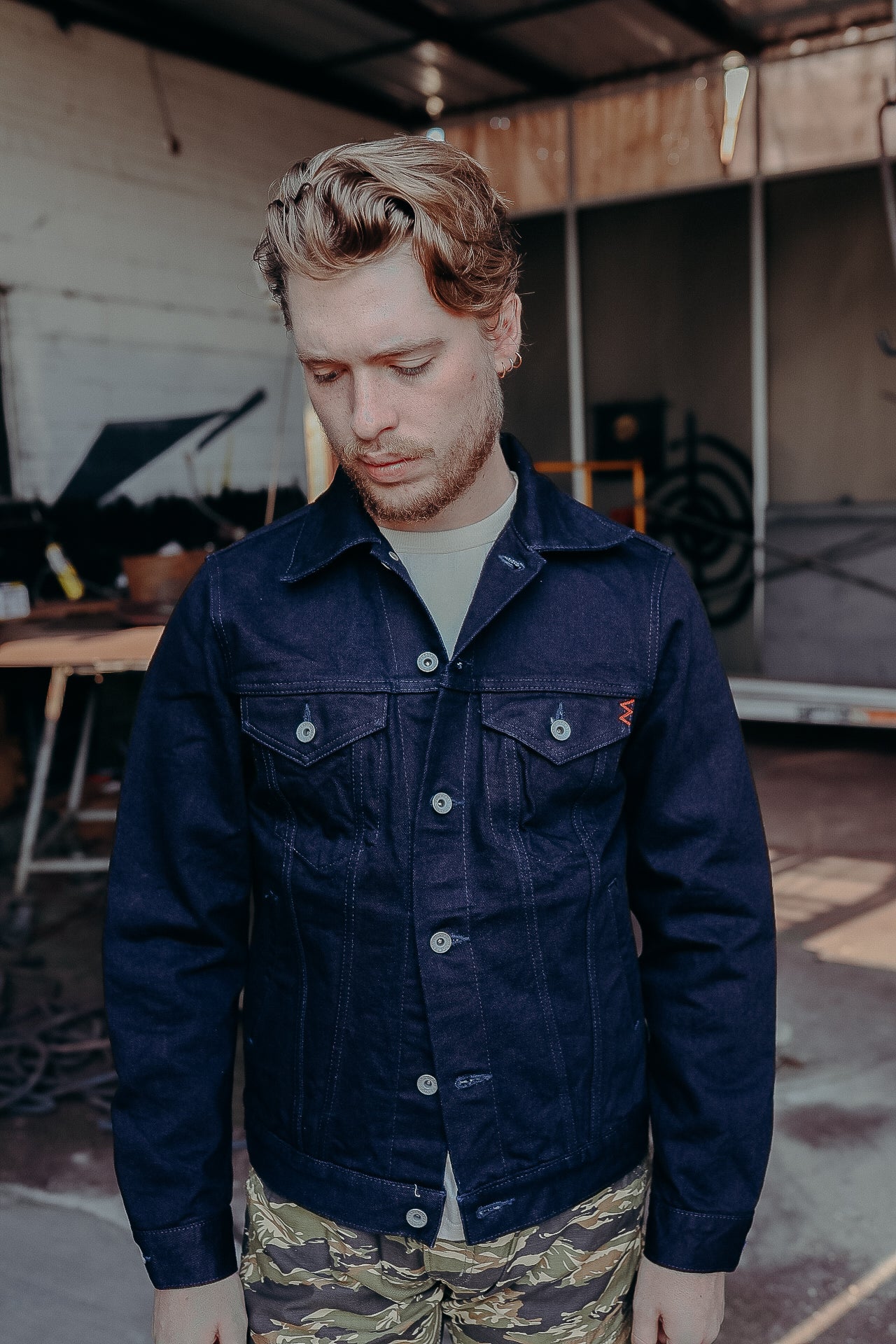 Person wearing a dark jacket and light blue jeans outdoors